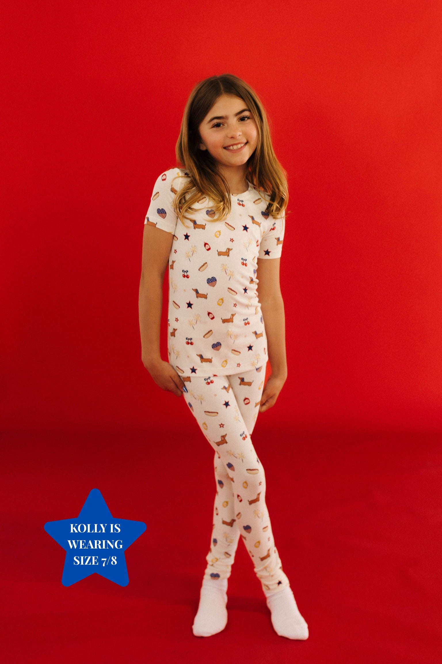 Young girl wearing a patterned pajama set on a red background