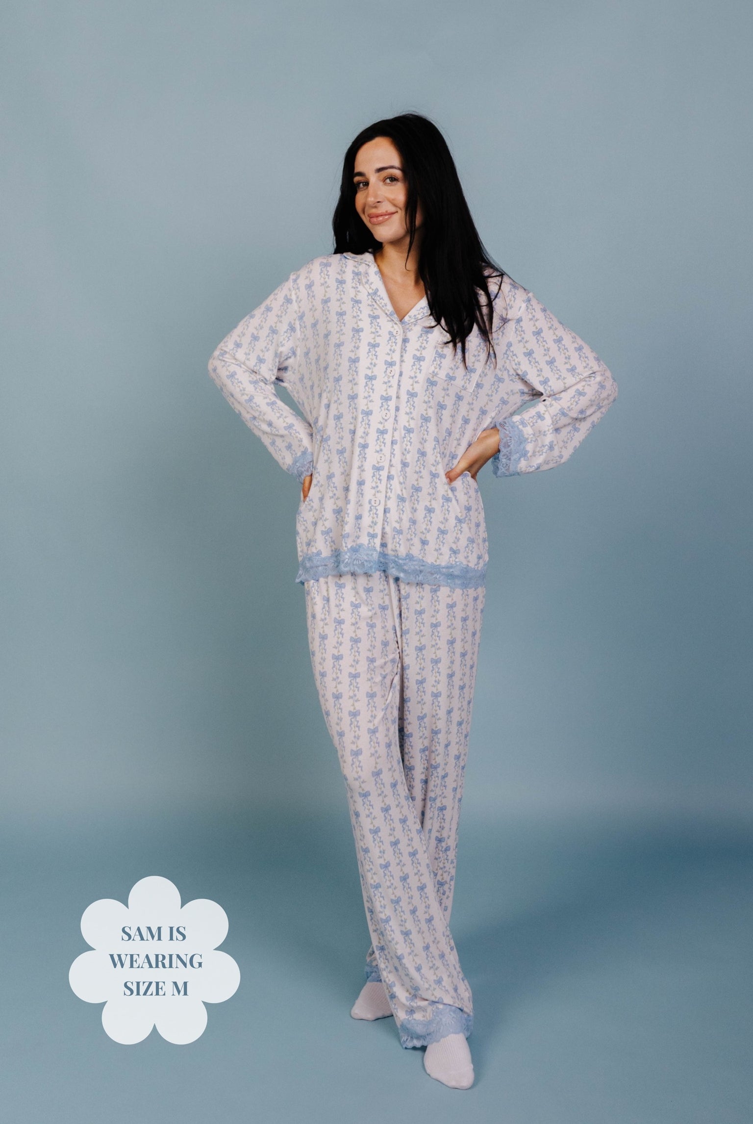 Woman wearing a patterned pajama set on a blue background. Size M