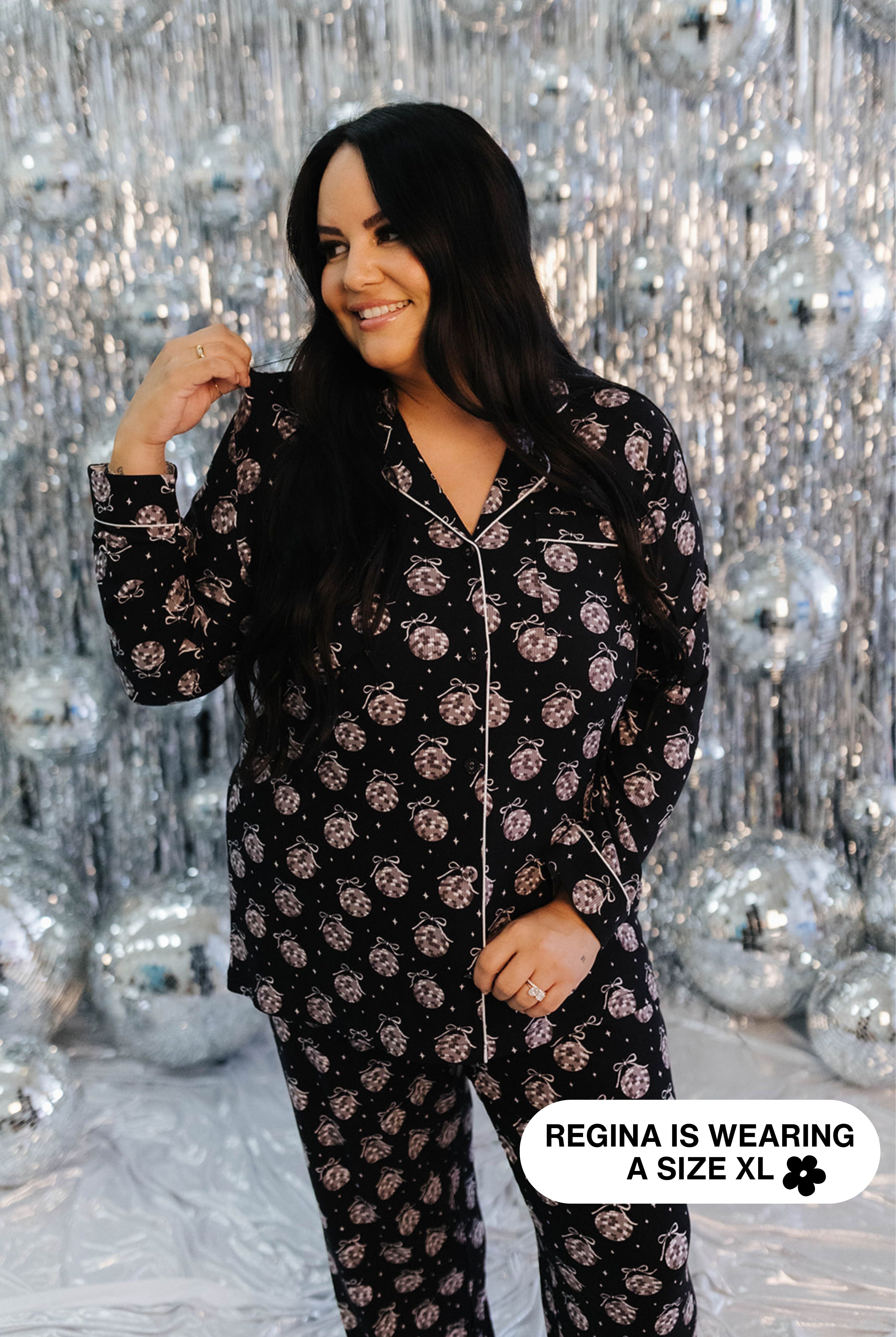 Woman wearing a black disco ball pajama set against a silver disco ball background