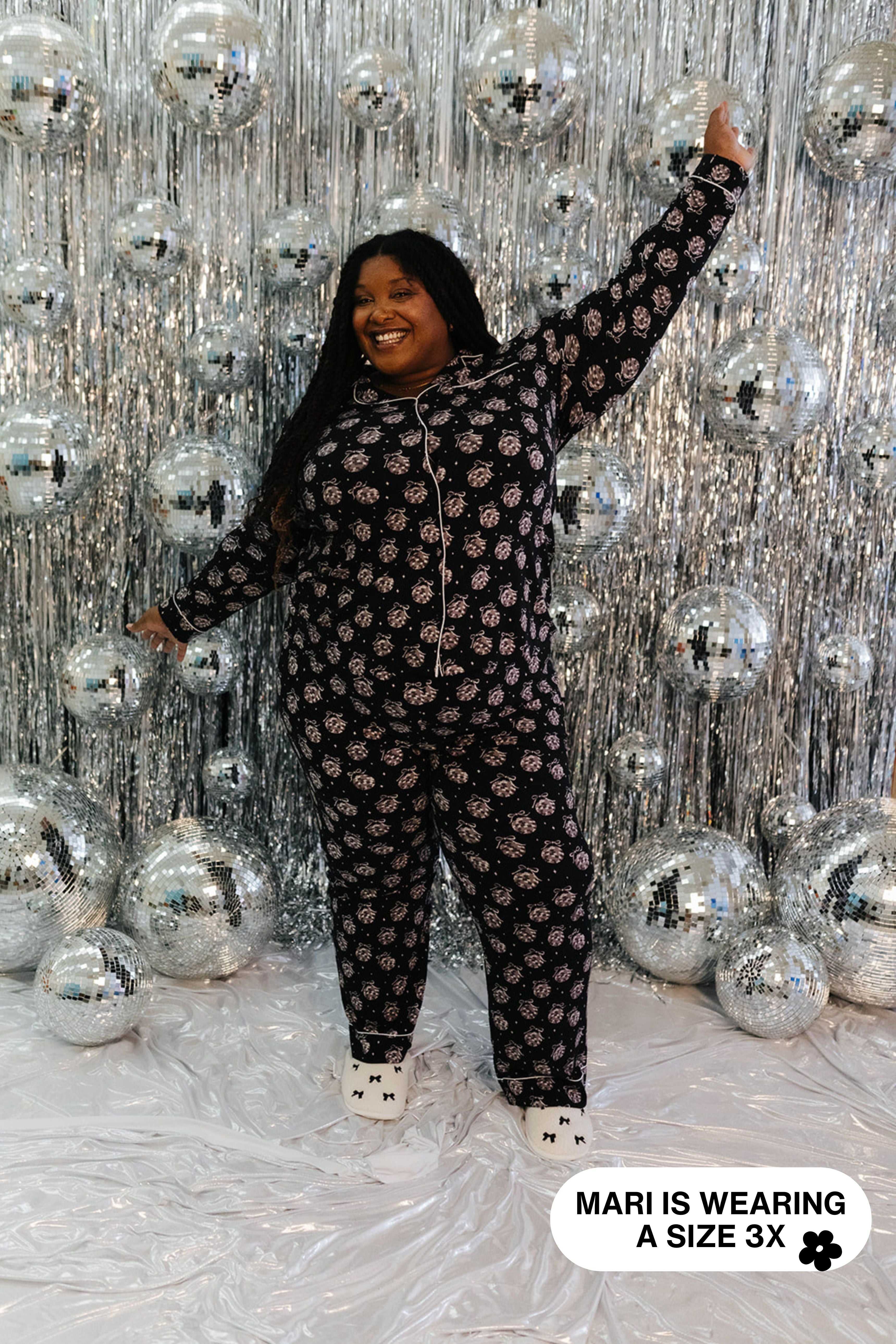 Person wearing a disco ball pajama set against a disco ball backdrop