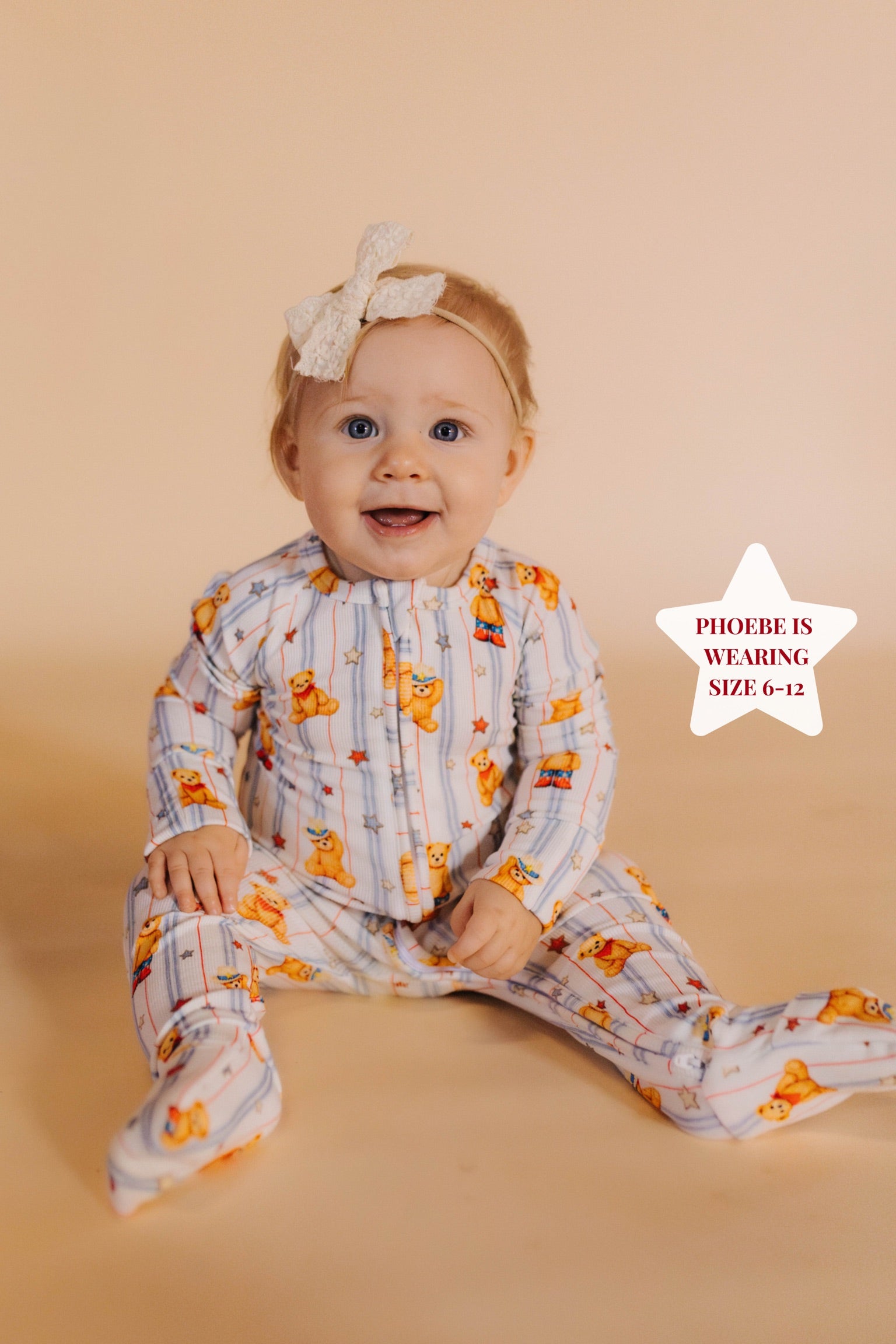 baby sitting on a cream background in teddy bear pjs