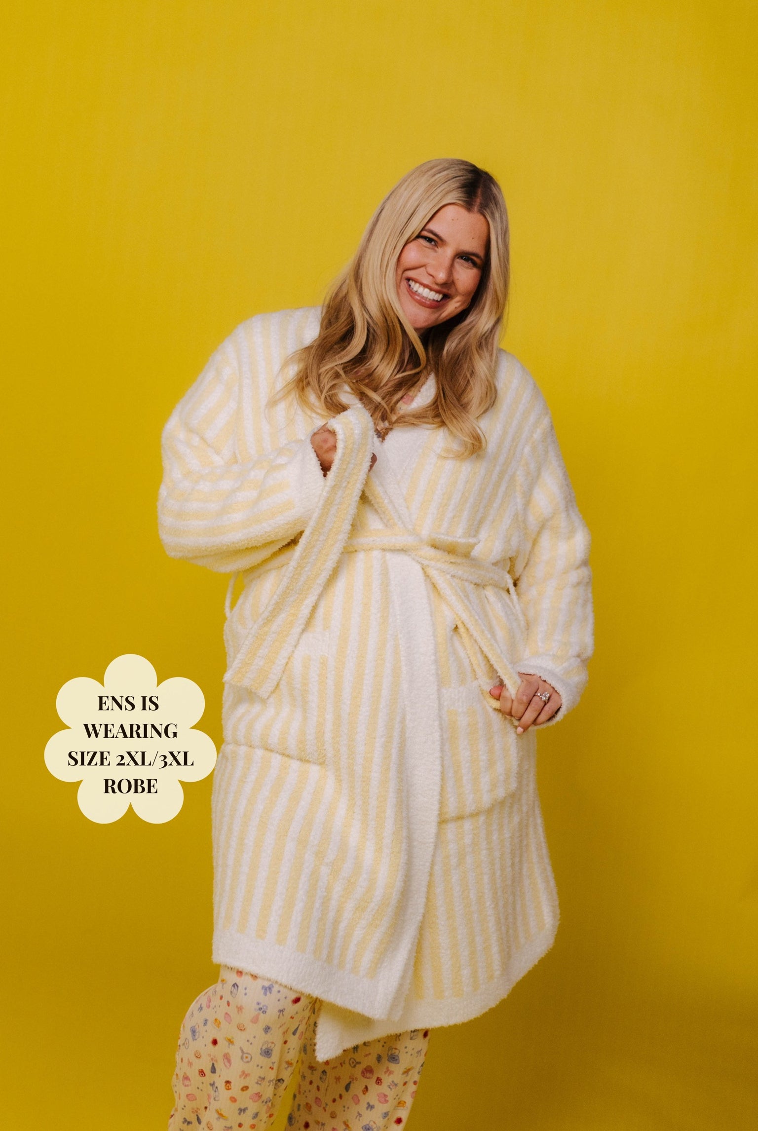 Woman wearing a yellow and white striped robe against a yellow background