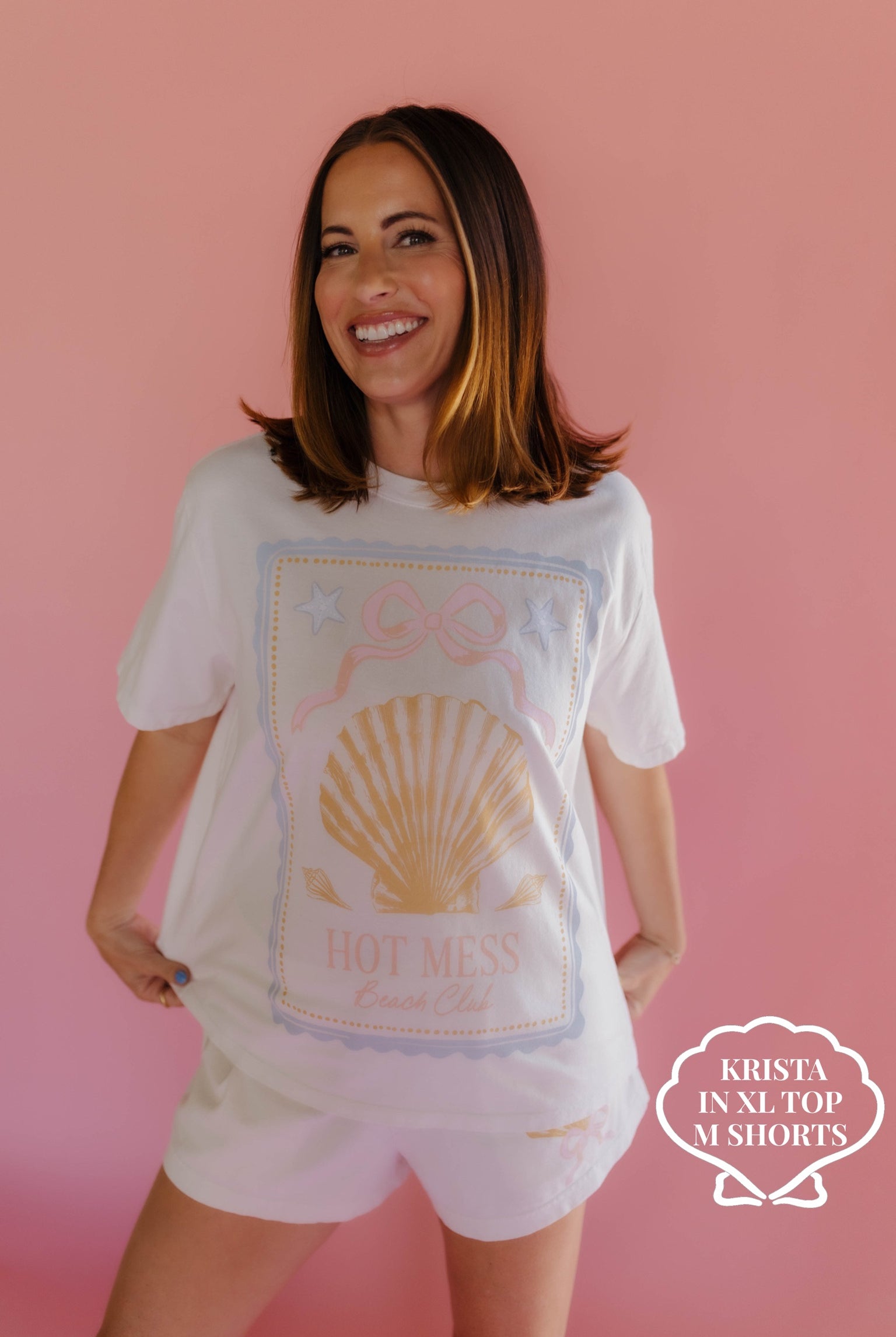 Woman wearing a white t-shirt with a graphic design on a pink background size XL/M