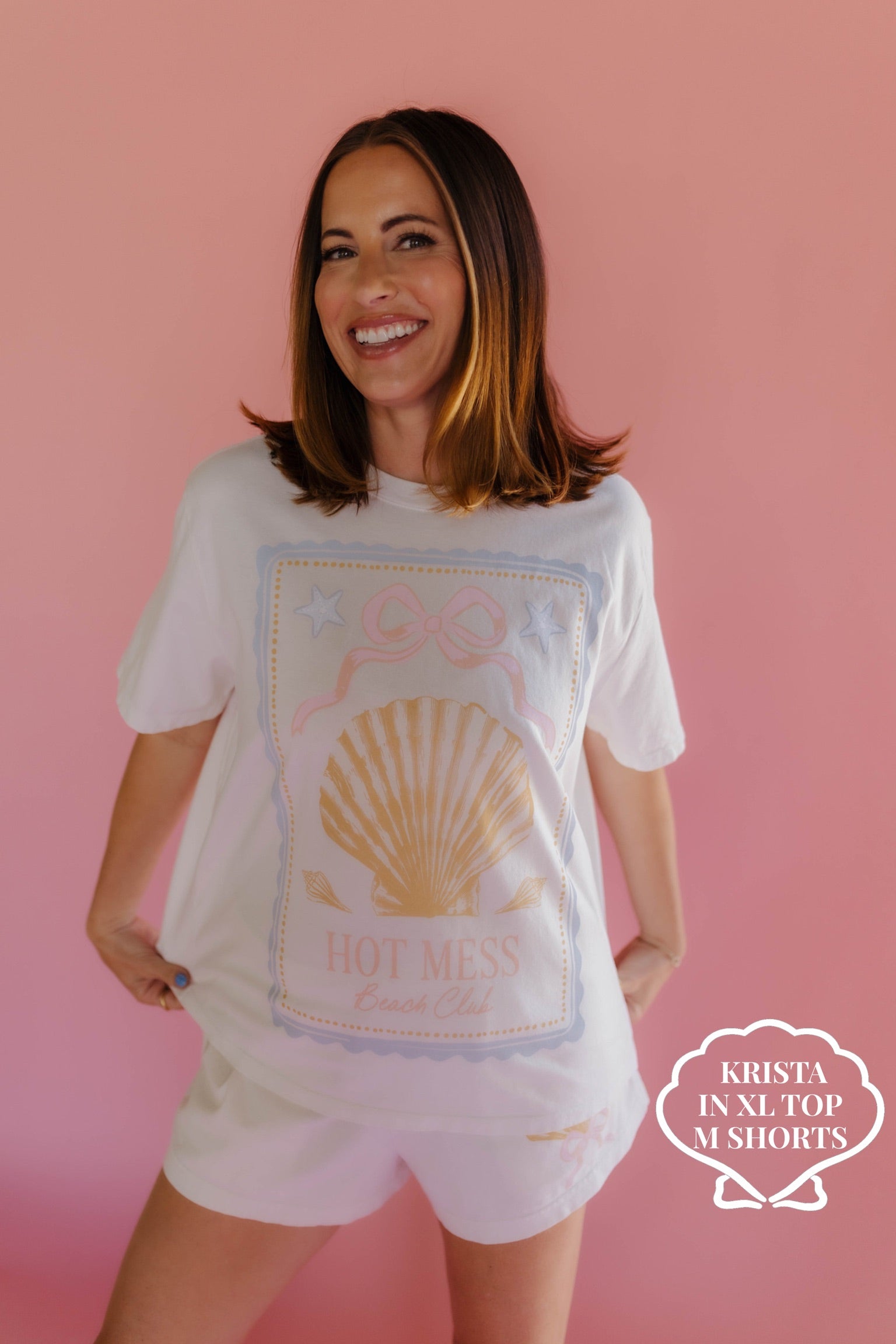 Woman wearing a white t-shirt with a graphic design on a pink background size XL/M