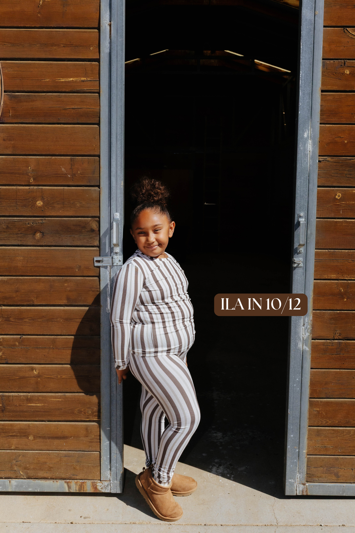 Sizing photo: Ilan in 10/12 wearing brown and cream striped kids pajama set.