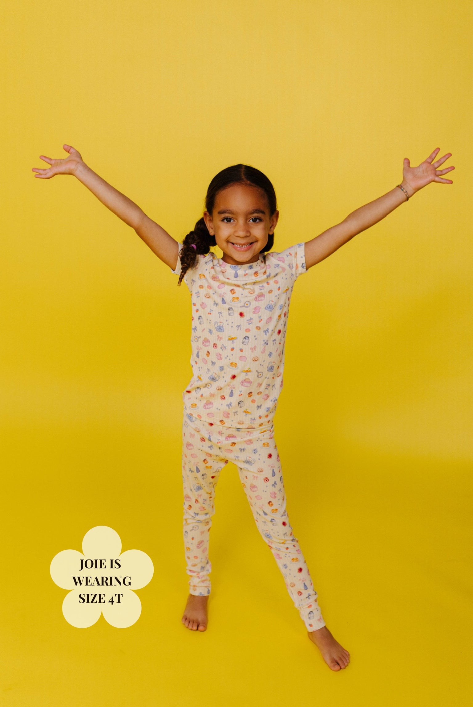 Young girl wearing a brunch pj set on a yellow background