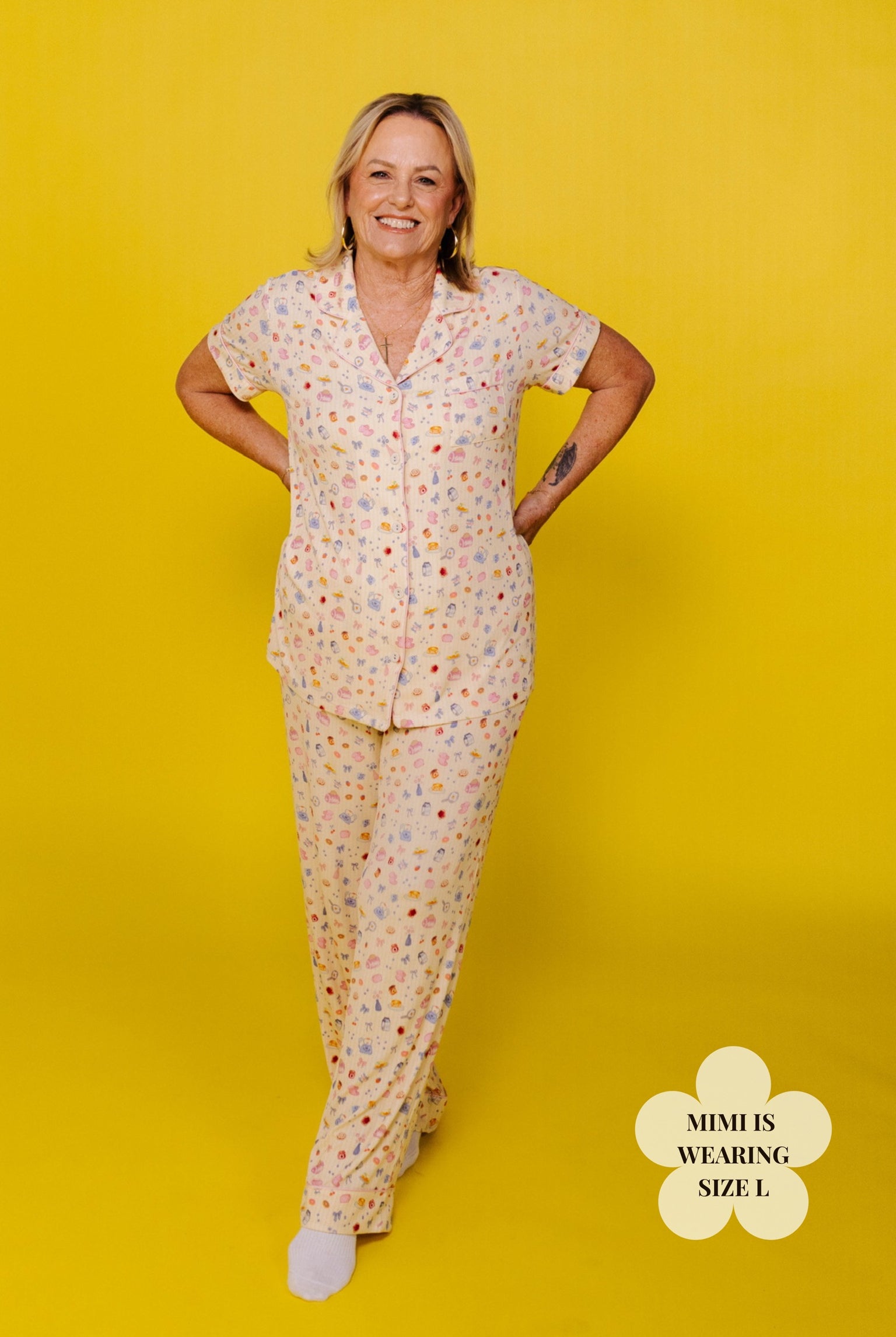Dena wearing a size L patterend pj on a yellow background
