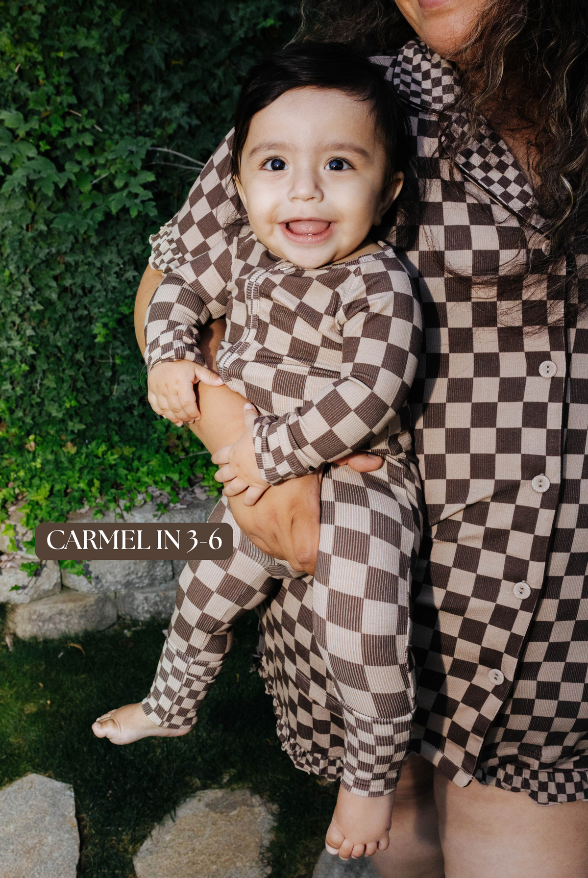 Sizing photo: Carmel in 3-6 months wearing brown check baby zip pajamas.