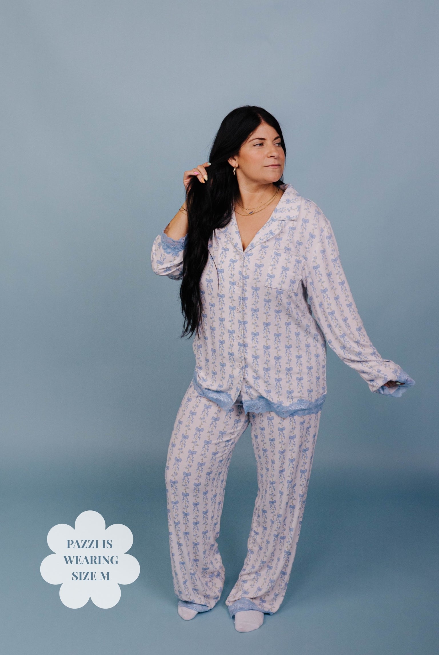 Woman wearing a patterned pajama set against a blue background. Size M