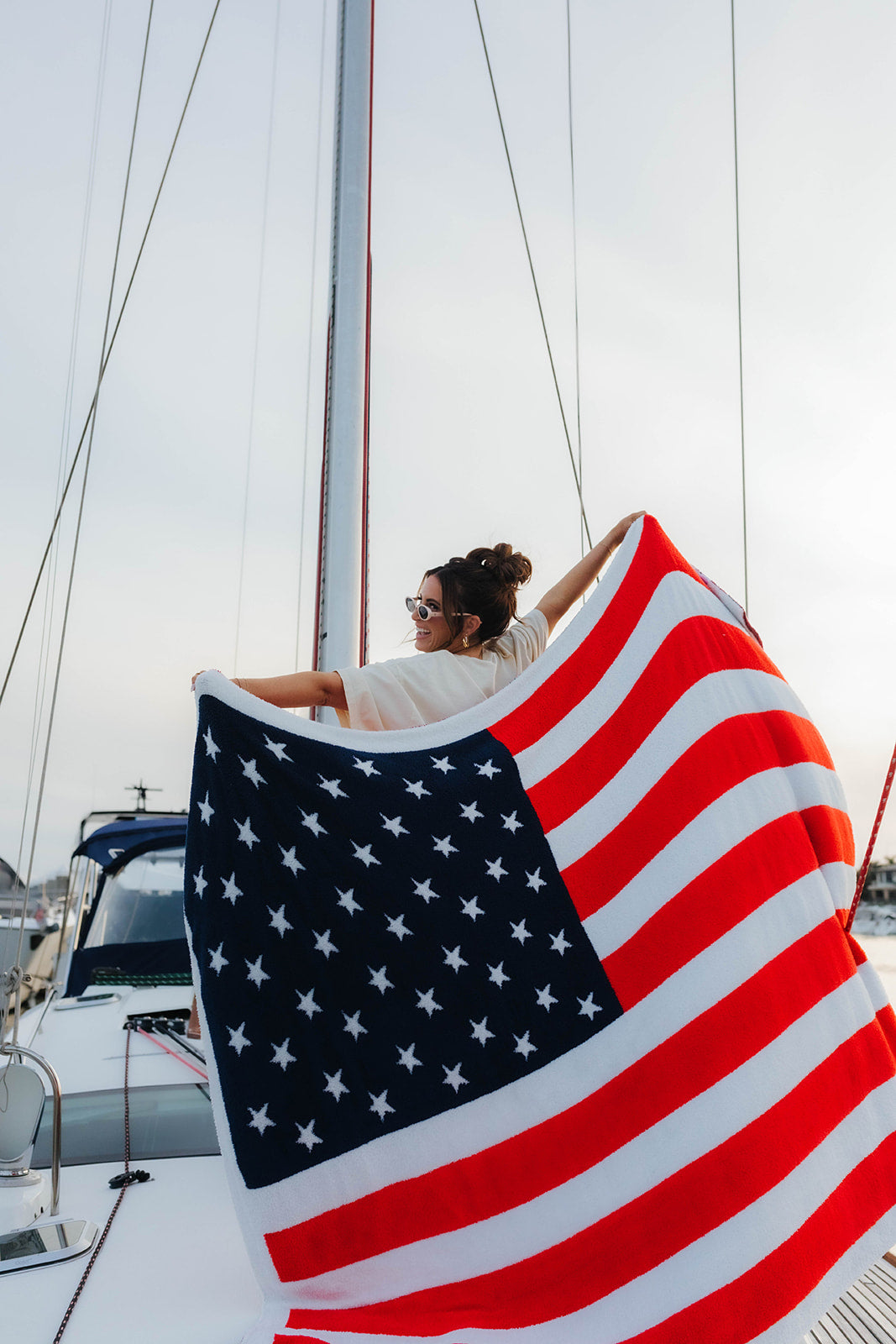woman holding up a blanket on the boat