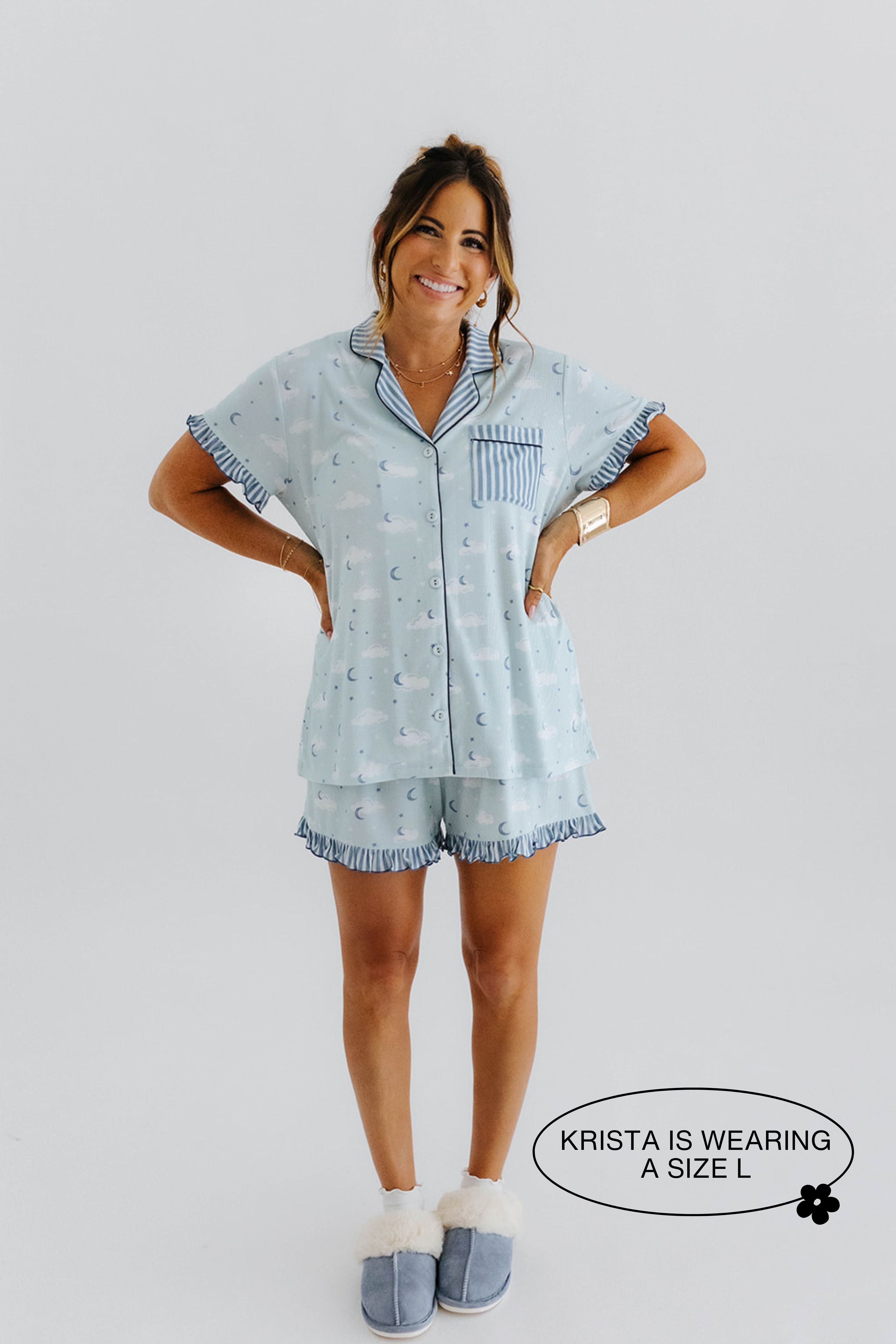 model krista smiling with hands on hips wearing a size large in the cloud ruffle pajamas