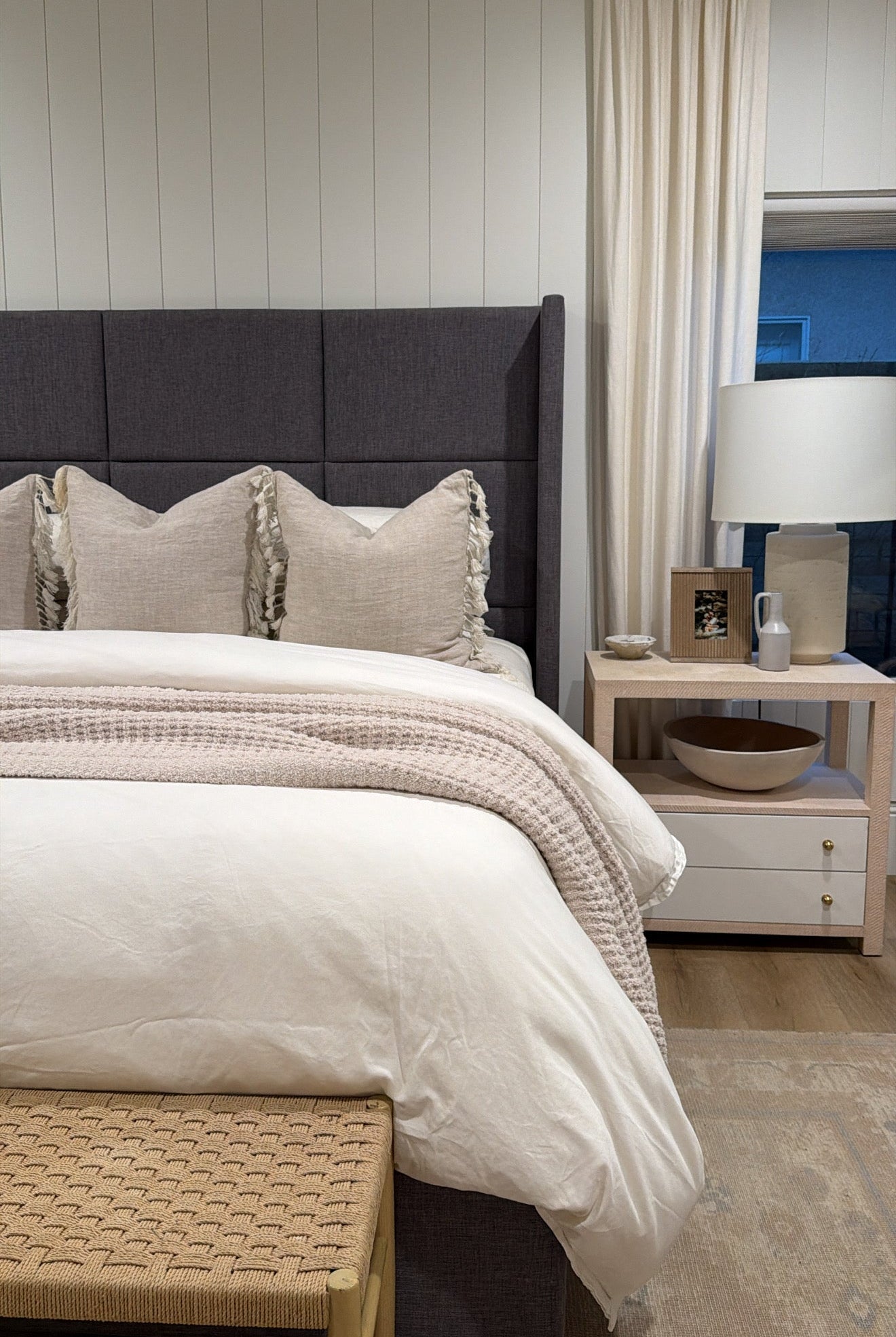 Neatly made bed with decorative pillows in a bedroom setting.