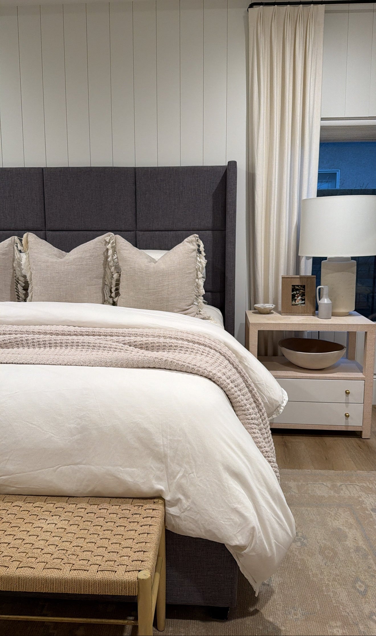 Neatly made bed with decorative pillows in a bedroom setting.