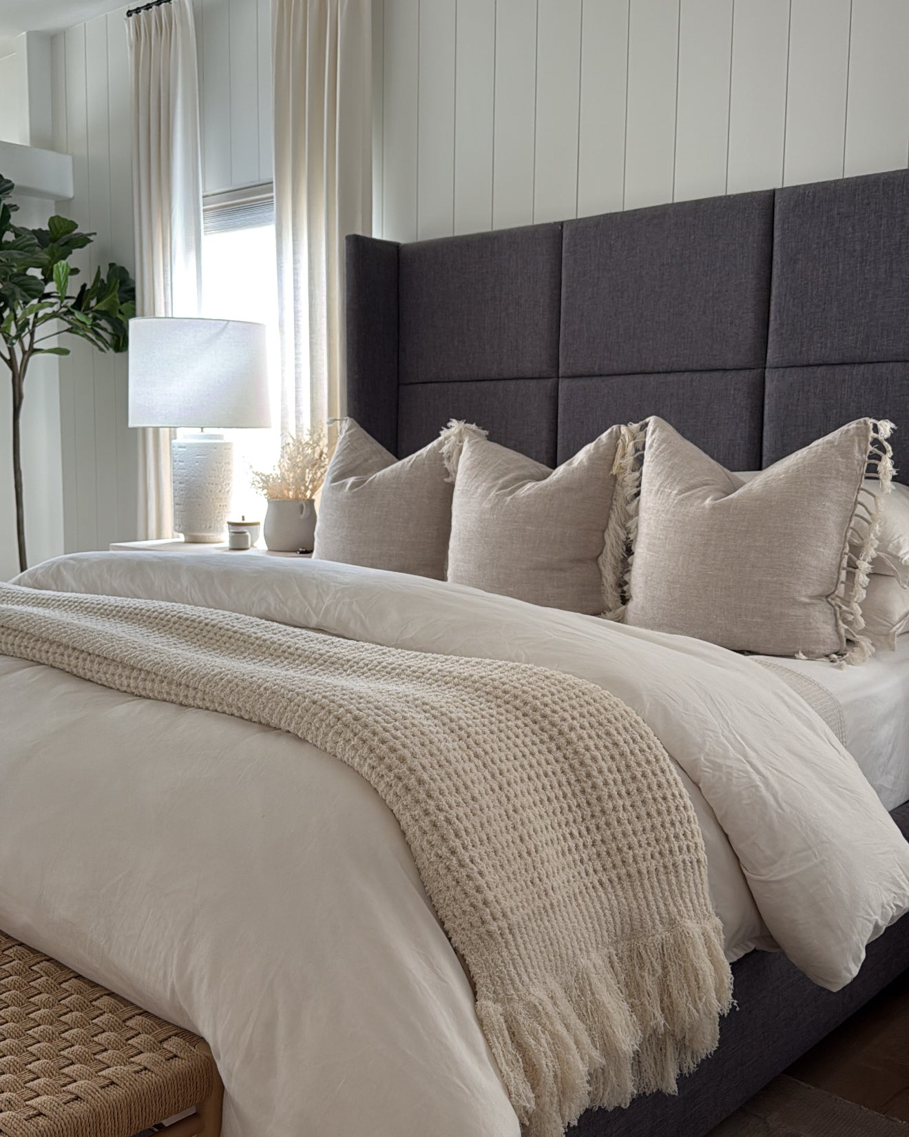 Neatly made bed with pillows and a blanket in a bedroom setting.