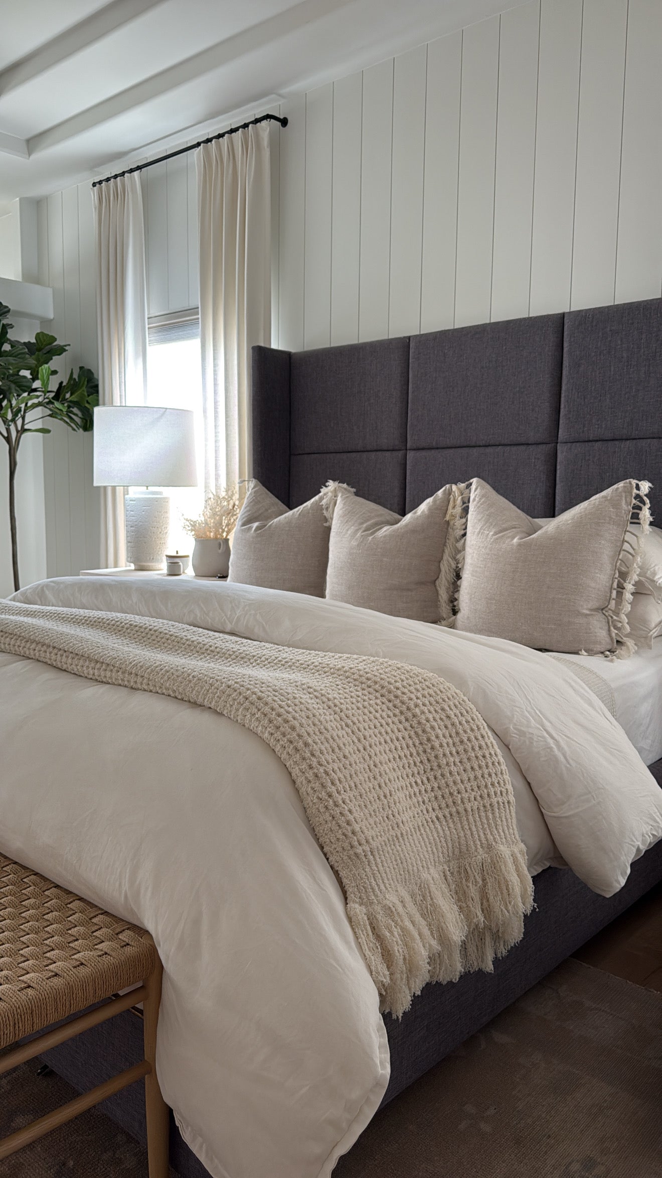 Neatly made bed with pillows and a blanket in a bedroom setting.