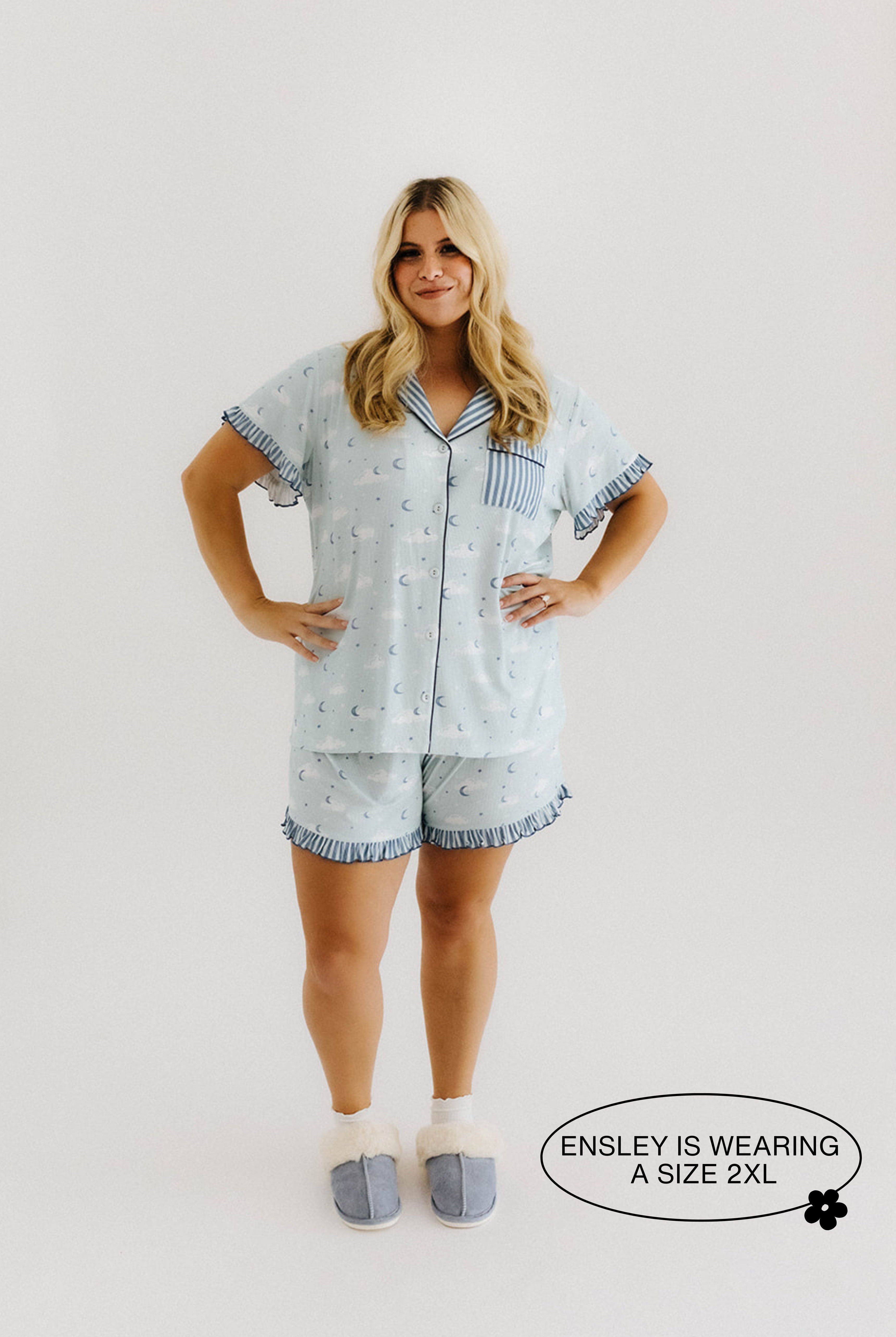 model ensley smiling with hands on hips wearing a size 2x in cloud ruffle pajamas
