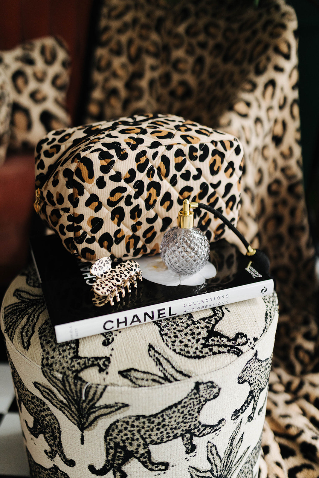 Leopard print bag and Chanel book on a patterned surface with leopard print background