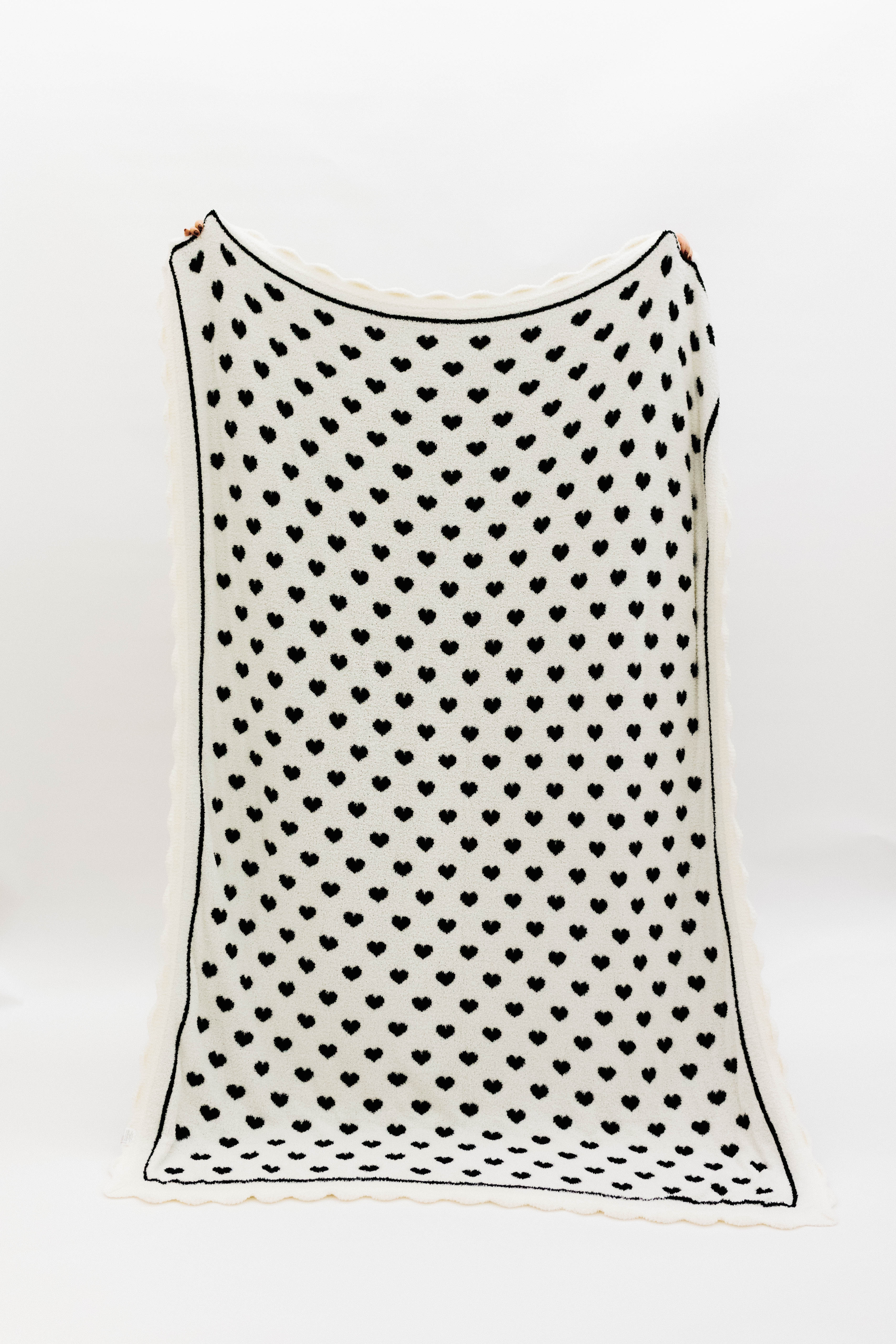 Other side of blanket showing a white base and black hearts