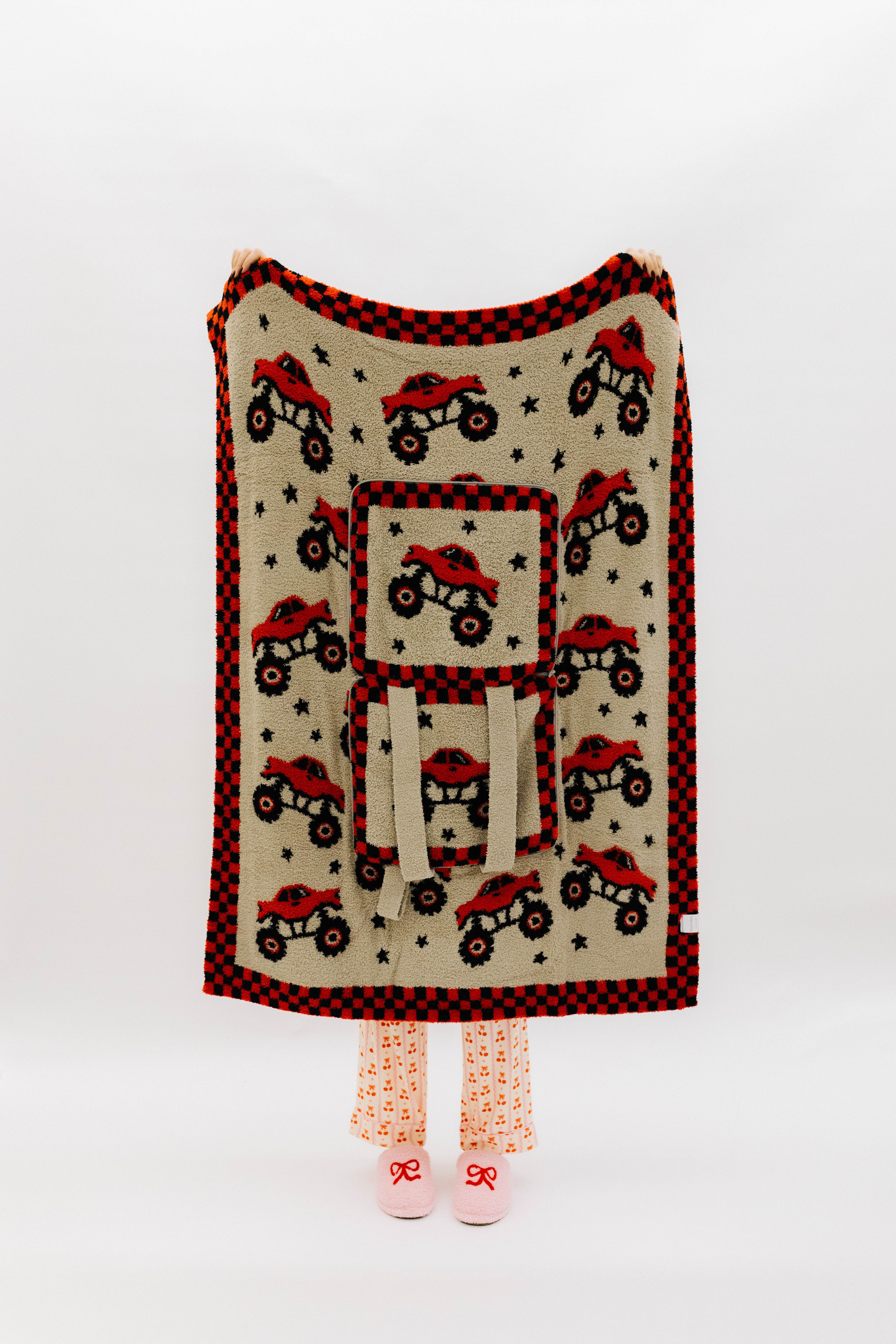 Monster truck quillow front, fully folded out and hanging to see the full design on trucks, stars, and check border