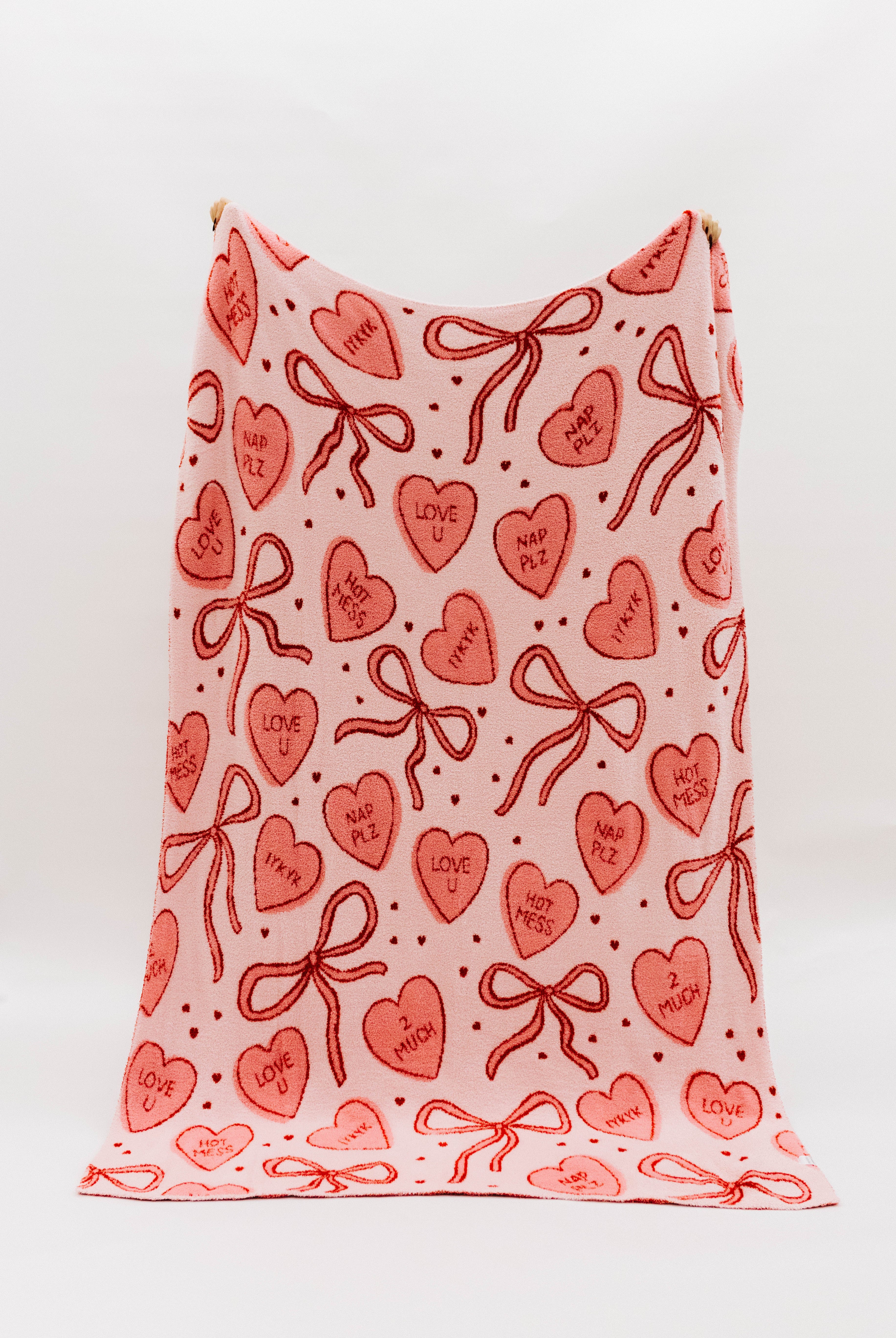 Pink blanket showing candy hearts and bows