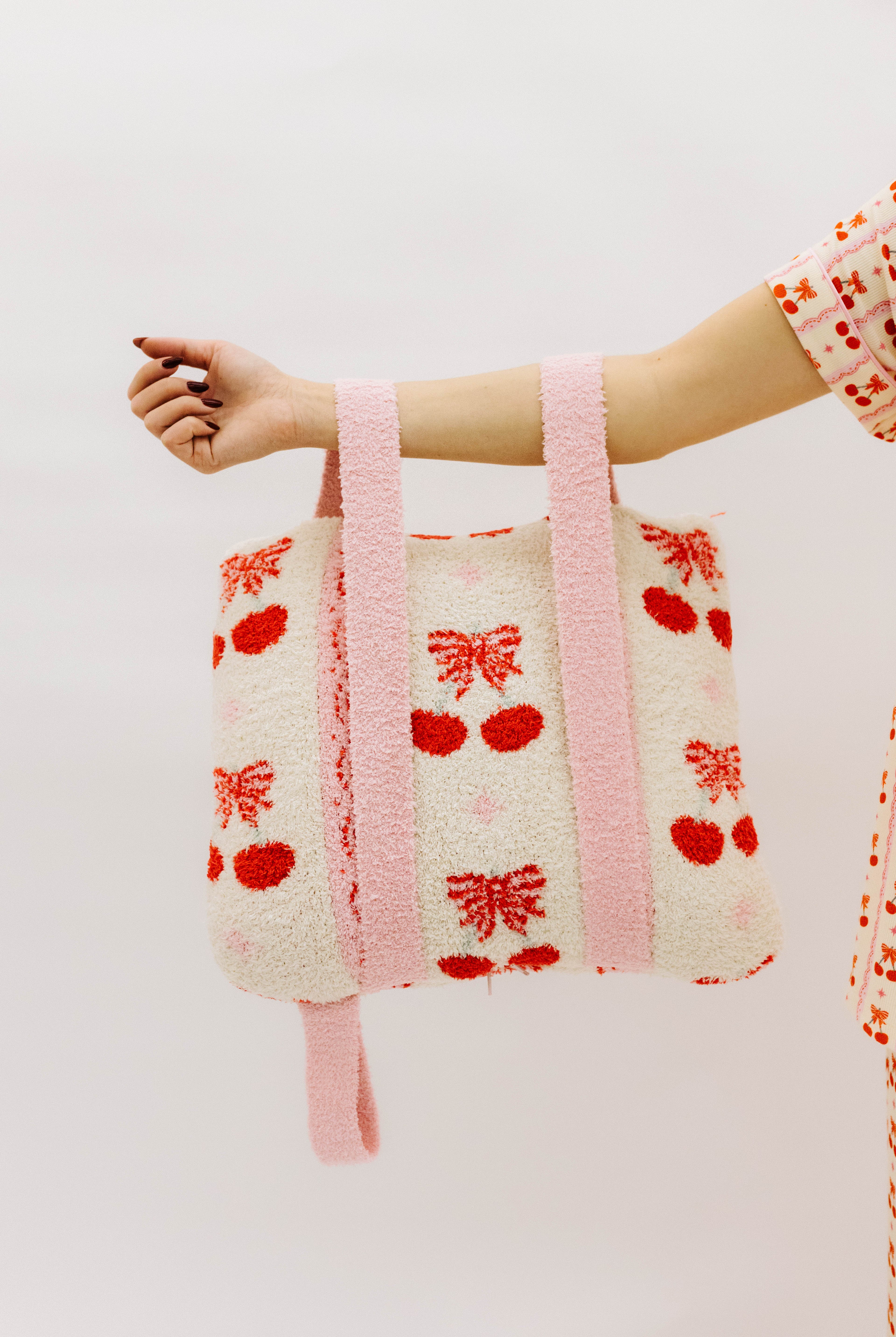 Holding the cherry quillow by the backpack straps