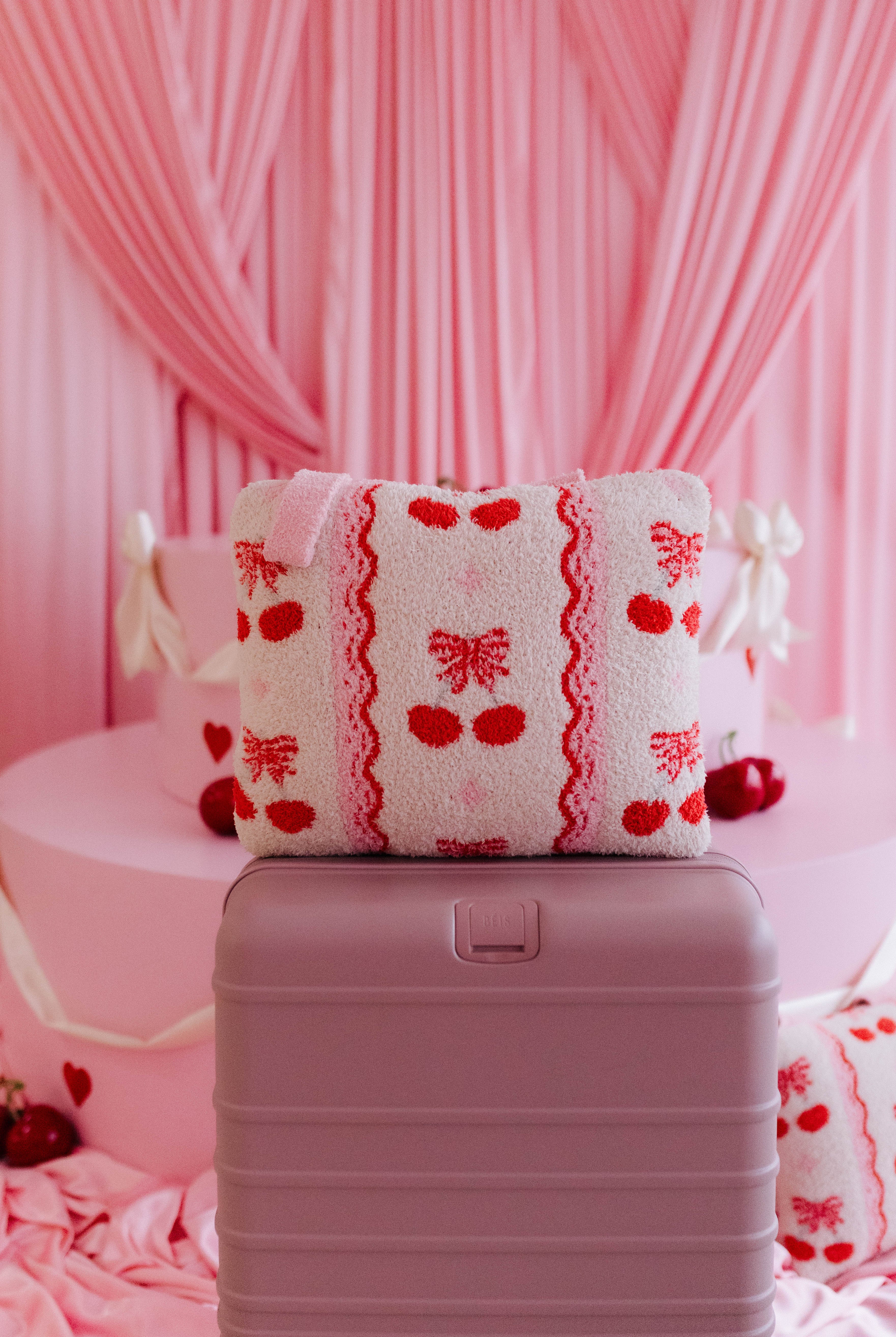 cherry quillow styled on a beis suitcase