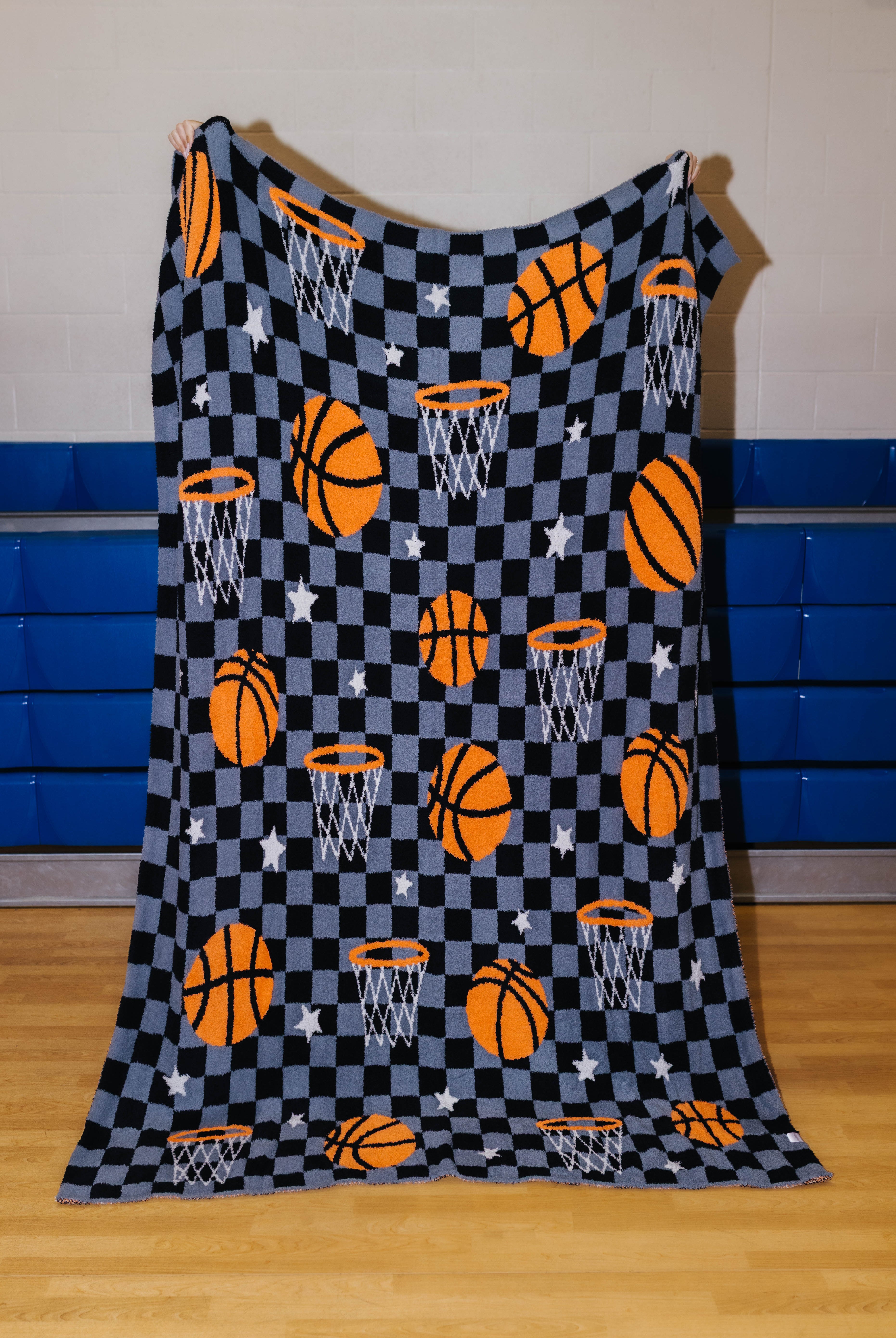 front of basketball blanket that has basketball, stars, hoops, and black/grey checkers