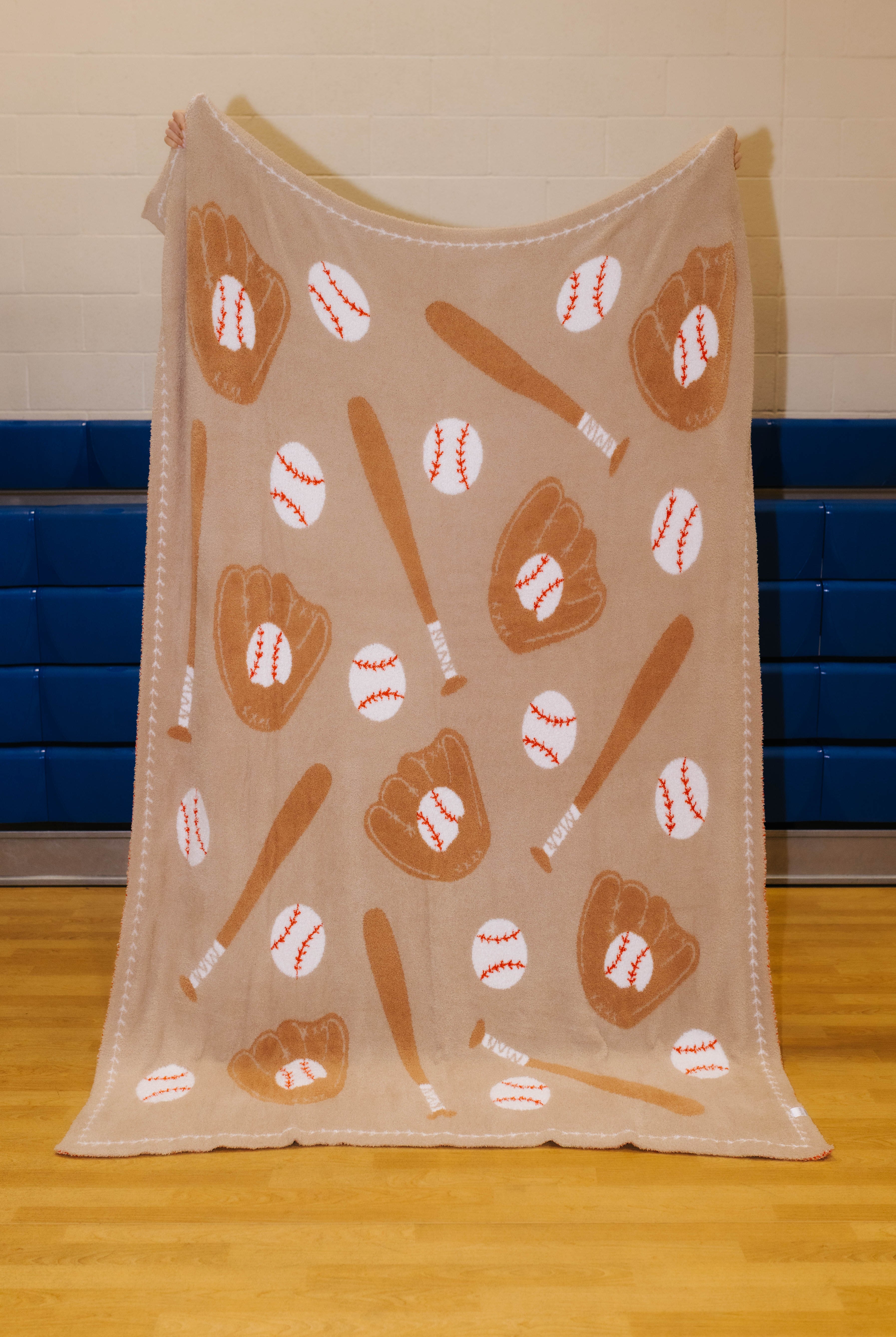 Front of baseball blanket with bats, glove, and balls - tan background and darker brown accents with white balls