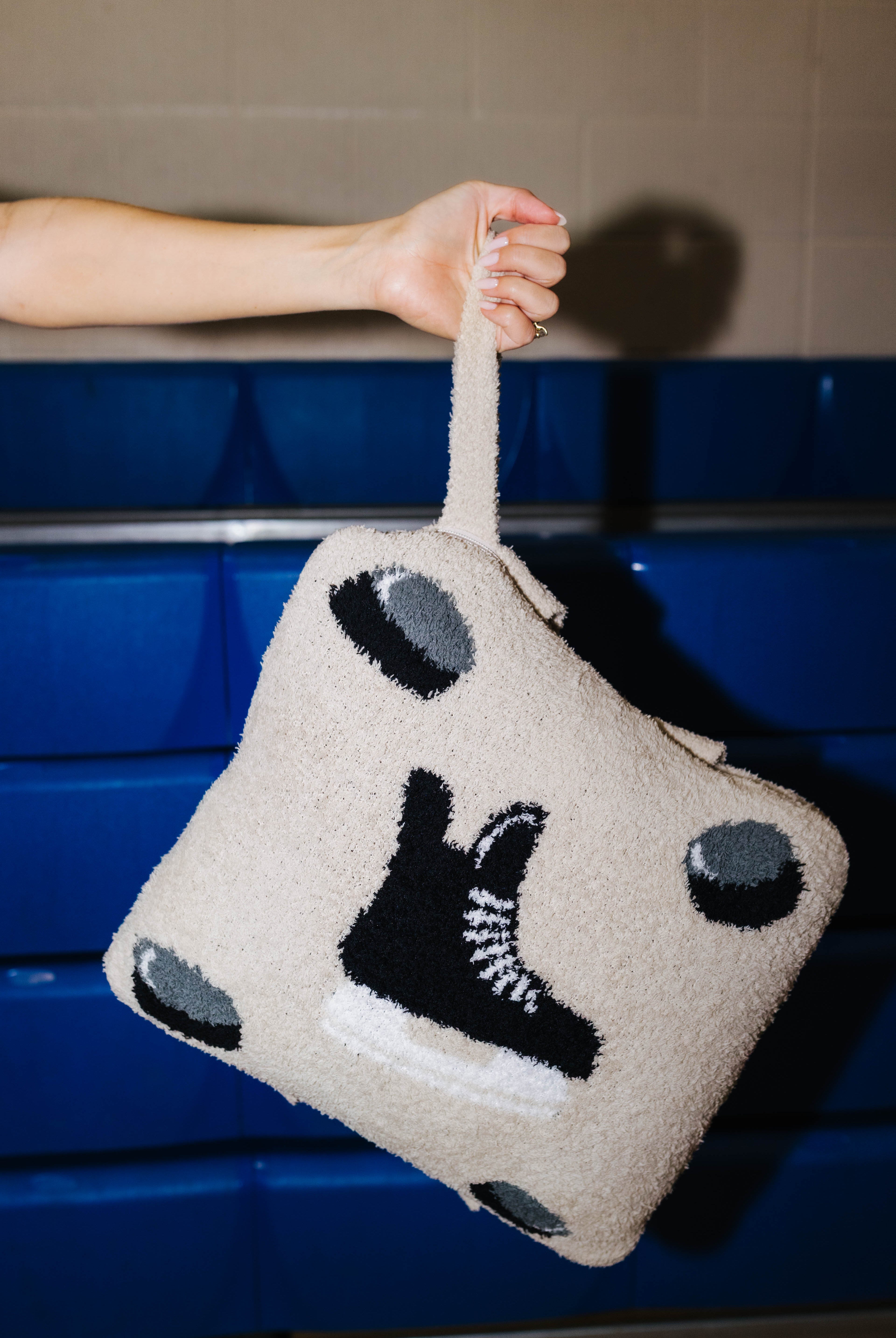 Holding the hockey quillow by the wristlet strap.