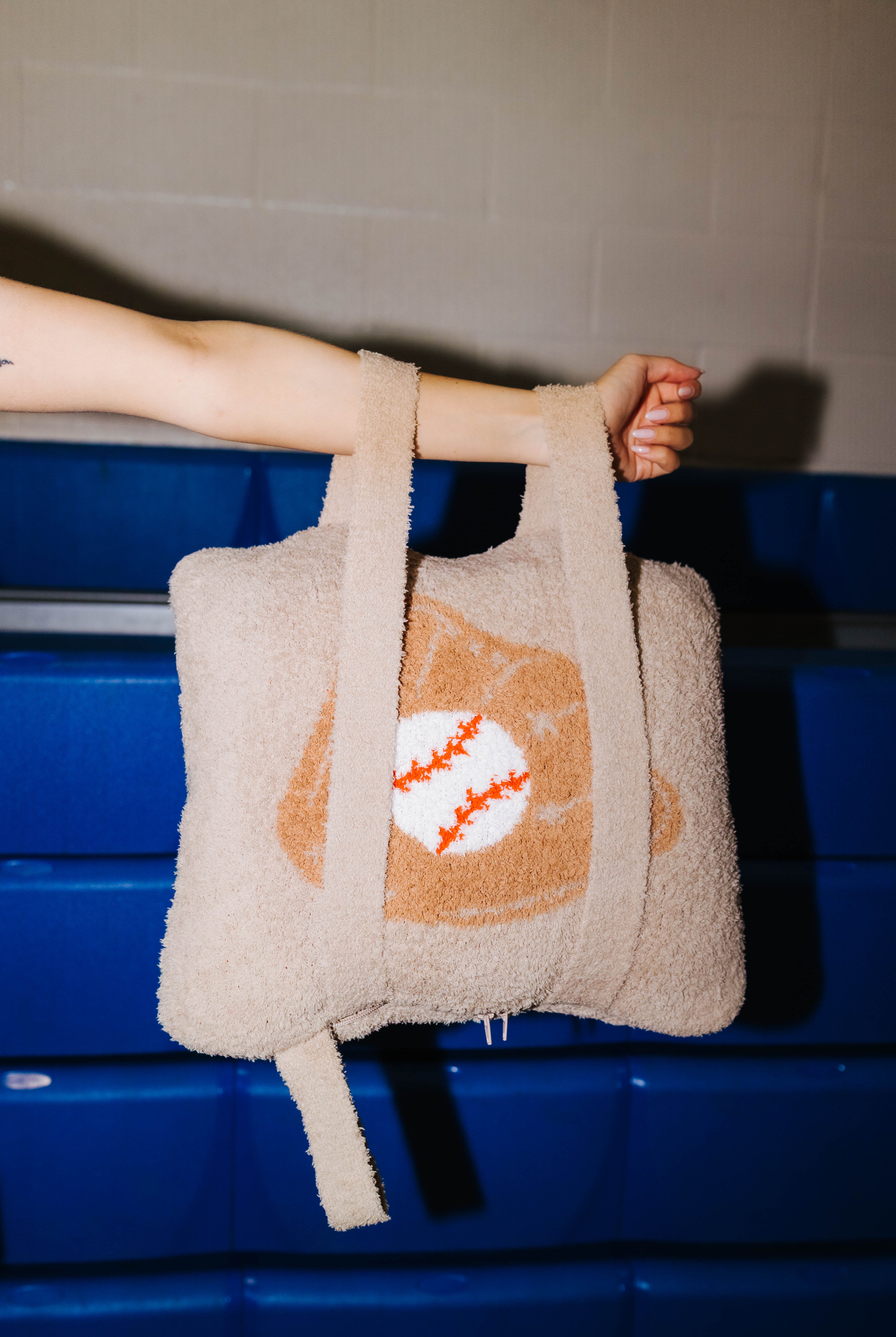 Holding the quillow by the arm showing the backpack straps