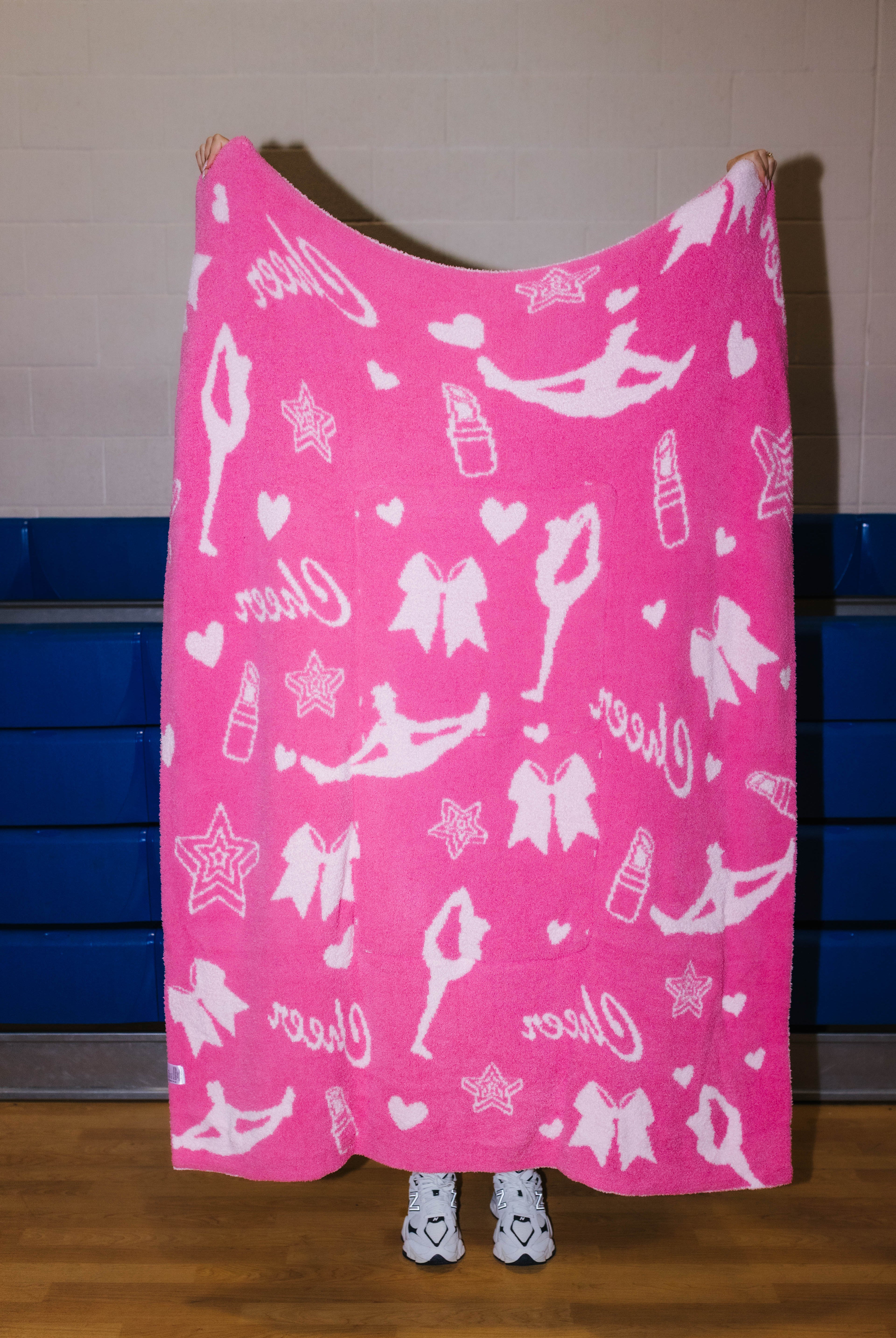 dark pink side of the cheer quillow showing light pink icons such as girls in stretches, lipstick, stars, hearts, cheer, and bows