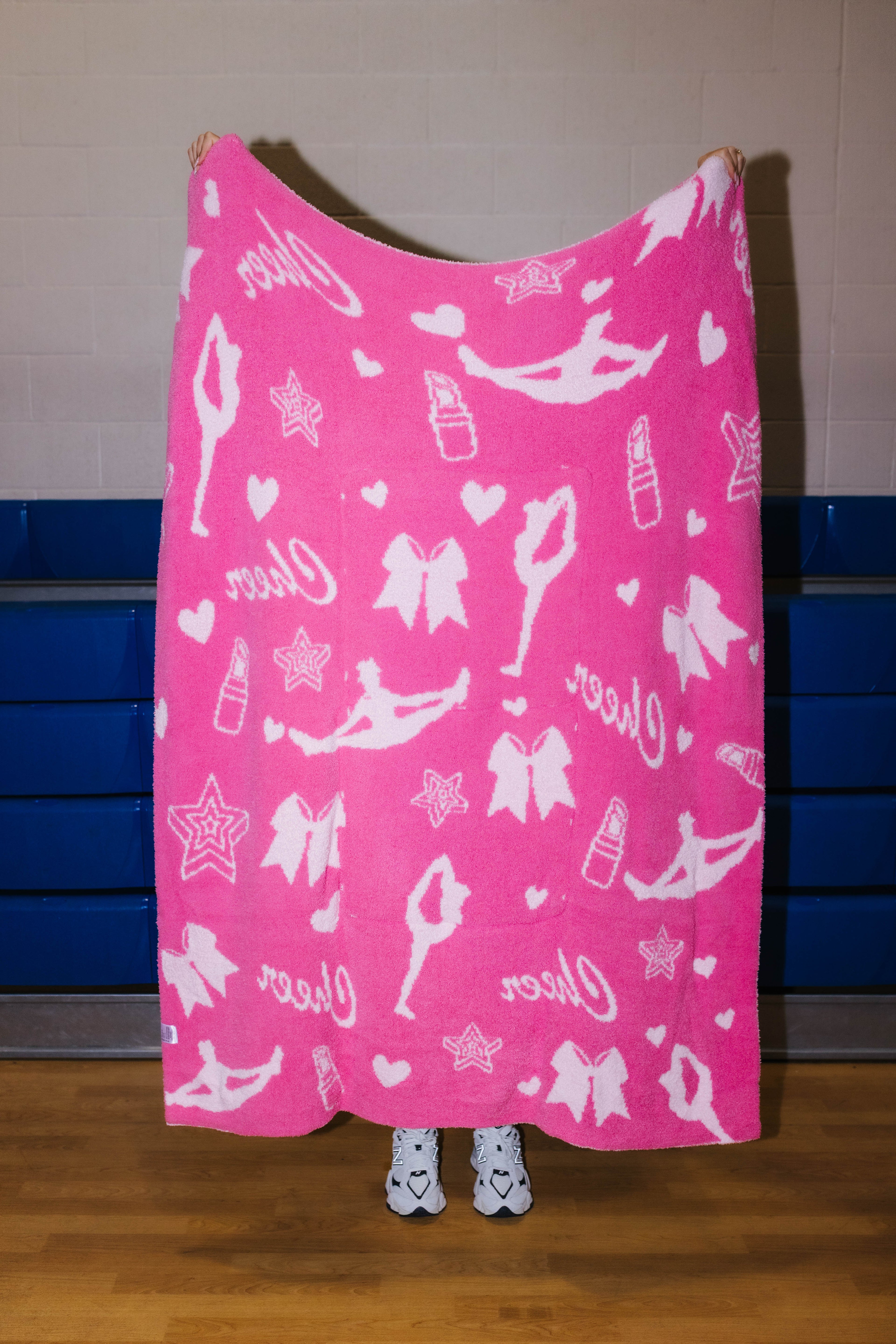dark pink side of the cheer quillow showing light pink icons such as girls in stretches, lipstick, stars, hearts, cheer, and bows