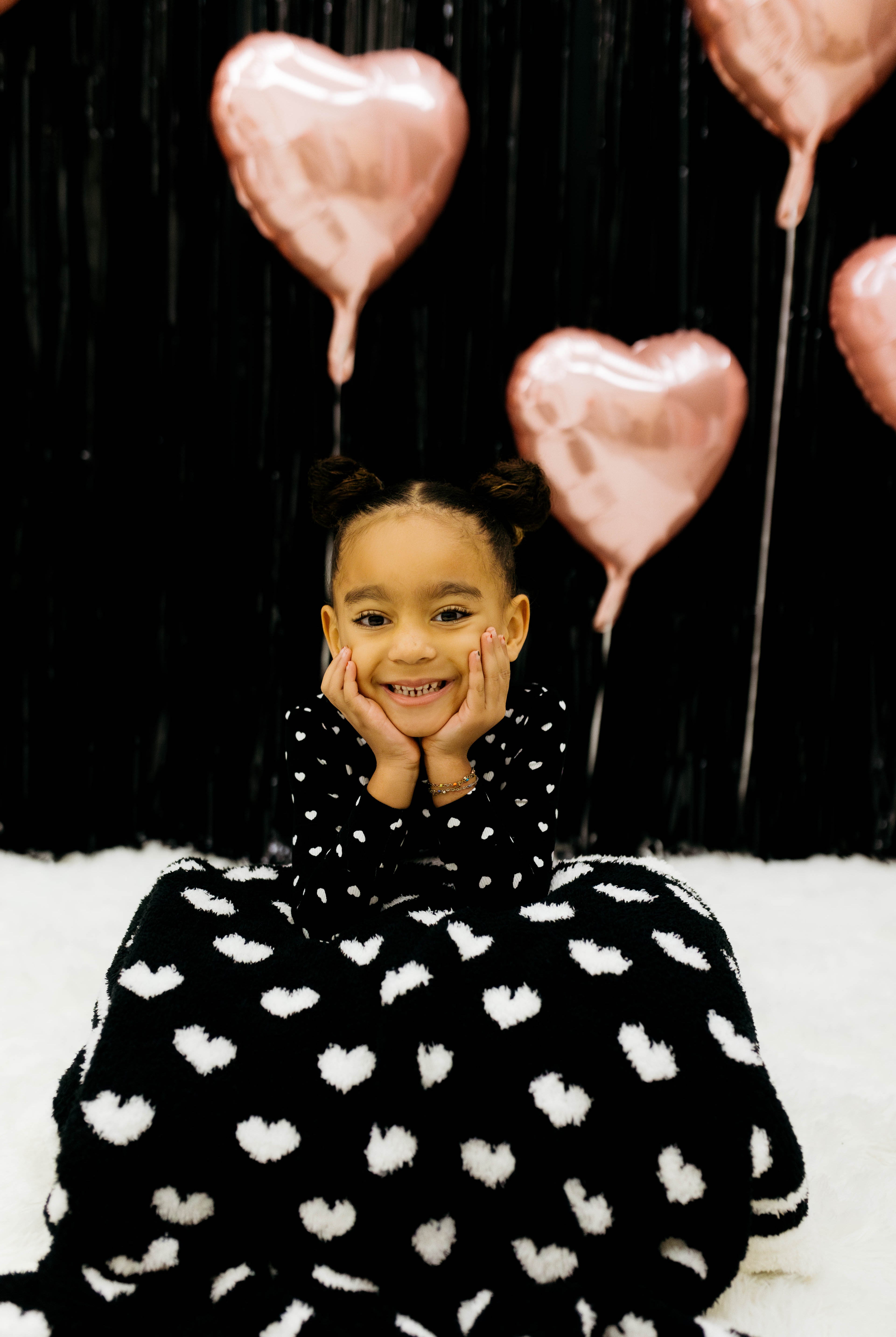 Child with the black side of the blanket draped on her lap