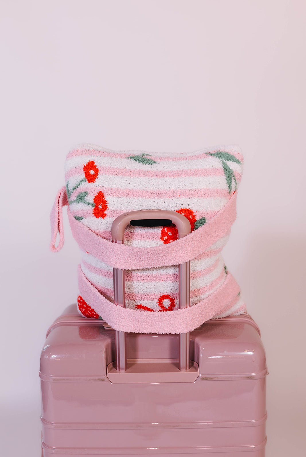 back side of the strawberry backpack quillow on the suitcase