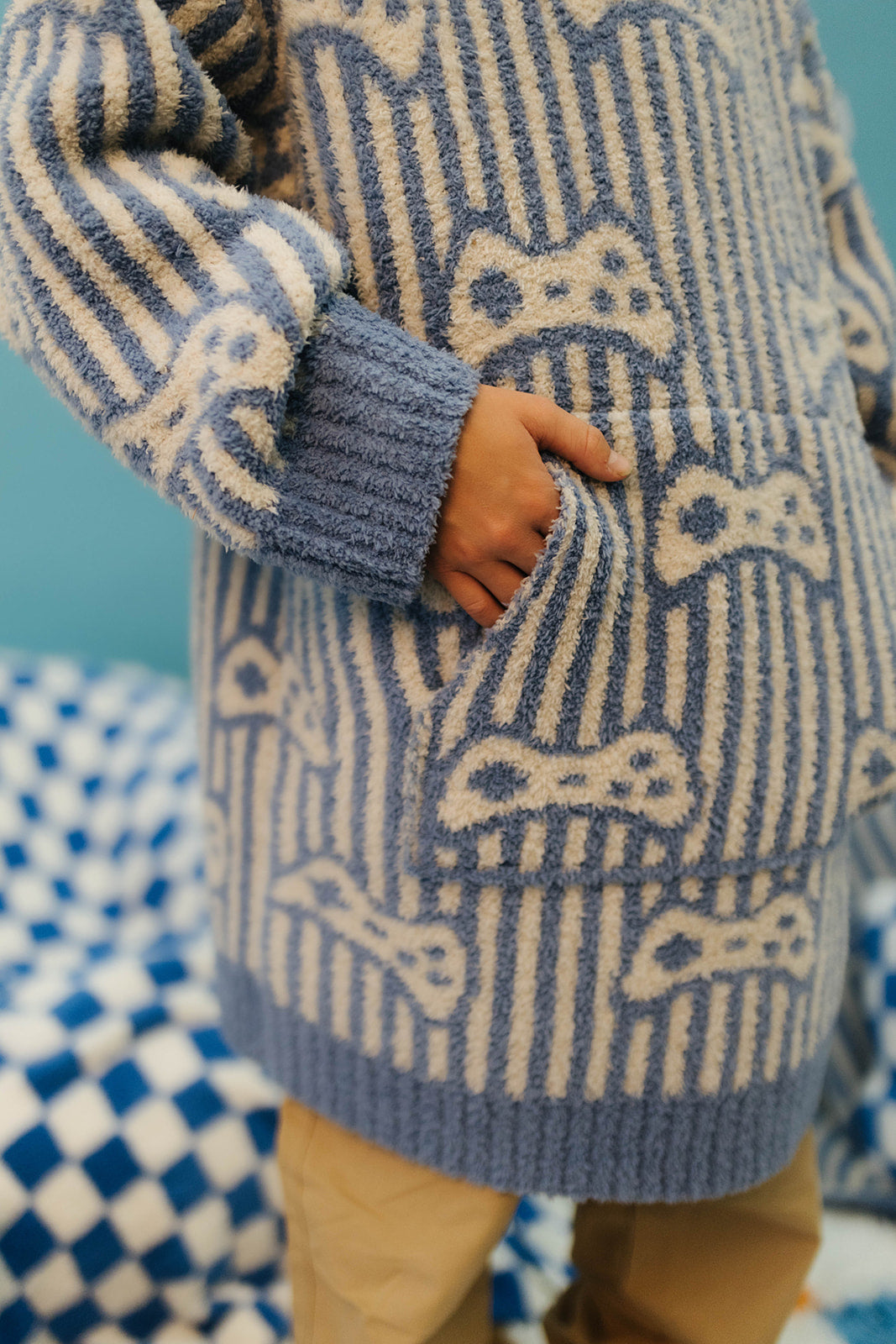 Person wearing a blue and white patterned sweater with a checkered background
