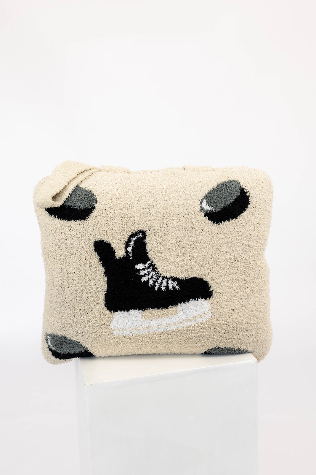 Beige quillow with black and white hockey pattern on a white background