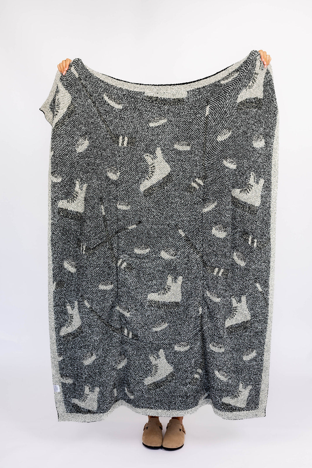 Gray patterned blanket with white hockey designs on a white background