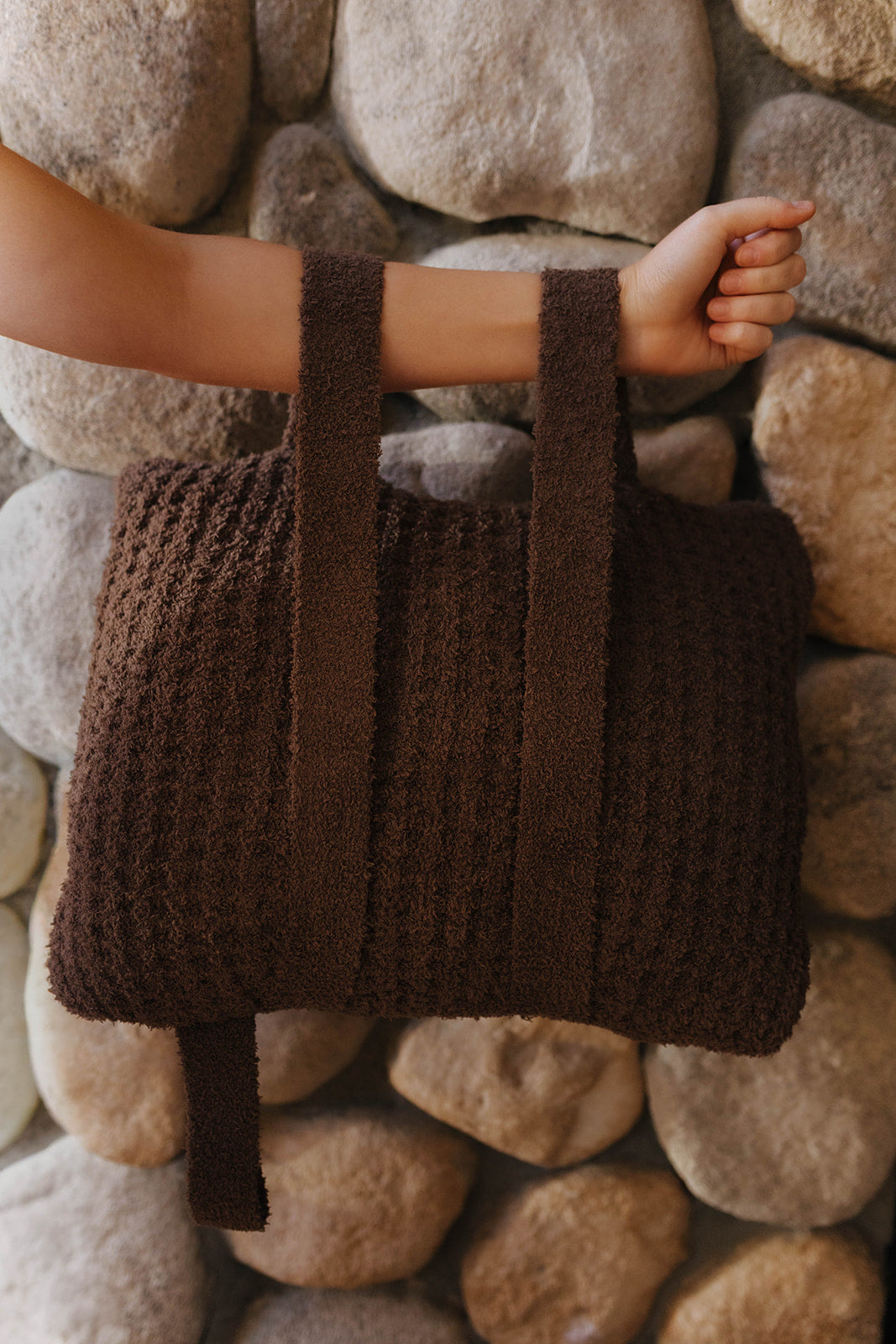 Brown waffle quillow folded with both backpack straps visible.