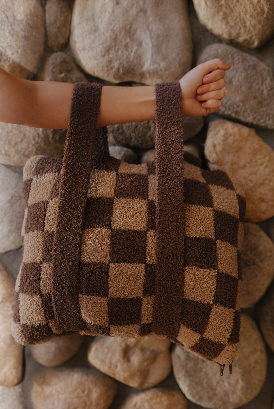 Brown check quillow folded with both backpack straps visible.