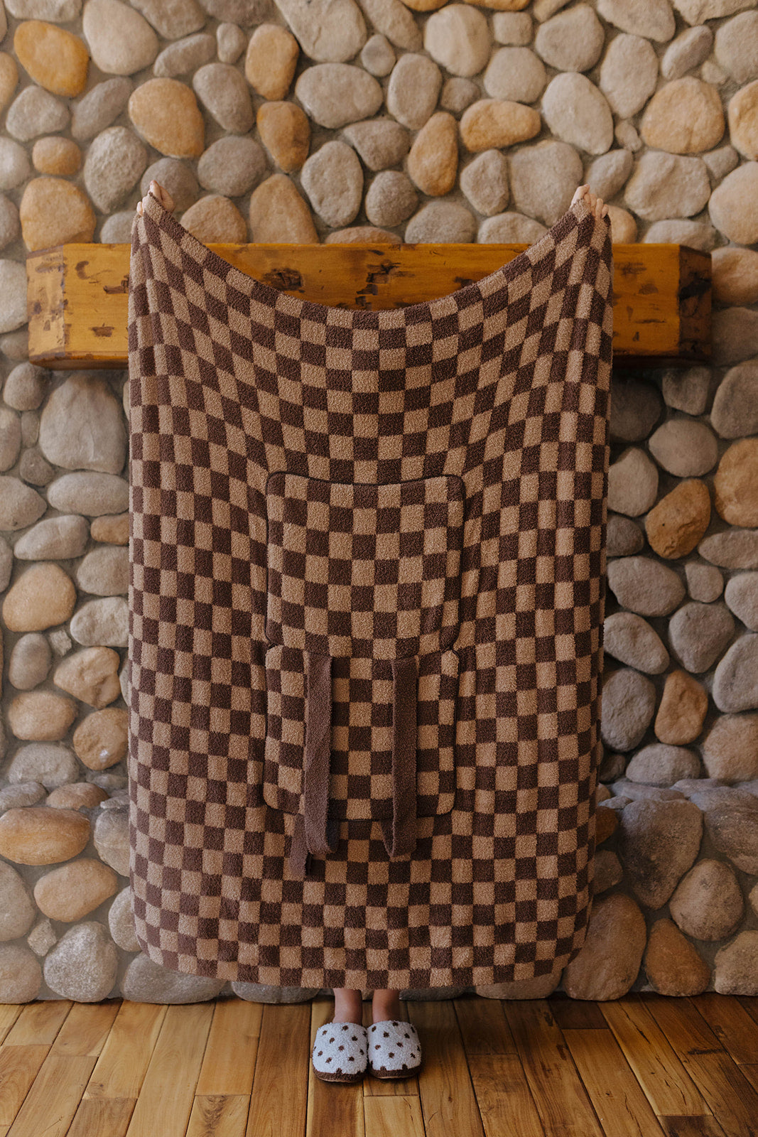 Tonal brown check quillow opened into a blanket with the pocket and straps visible.
