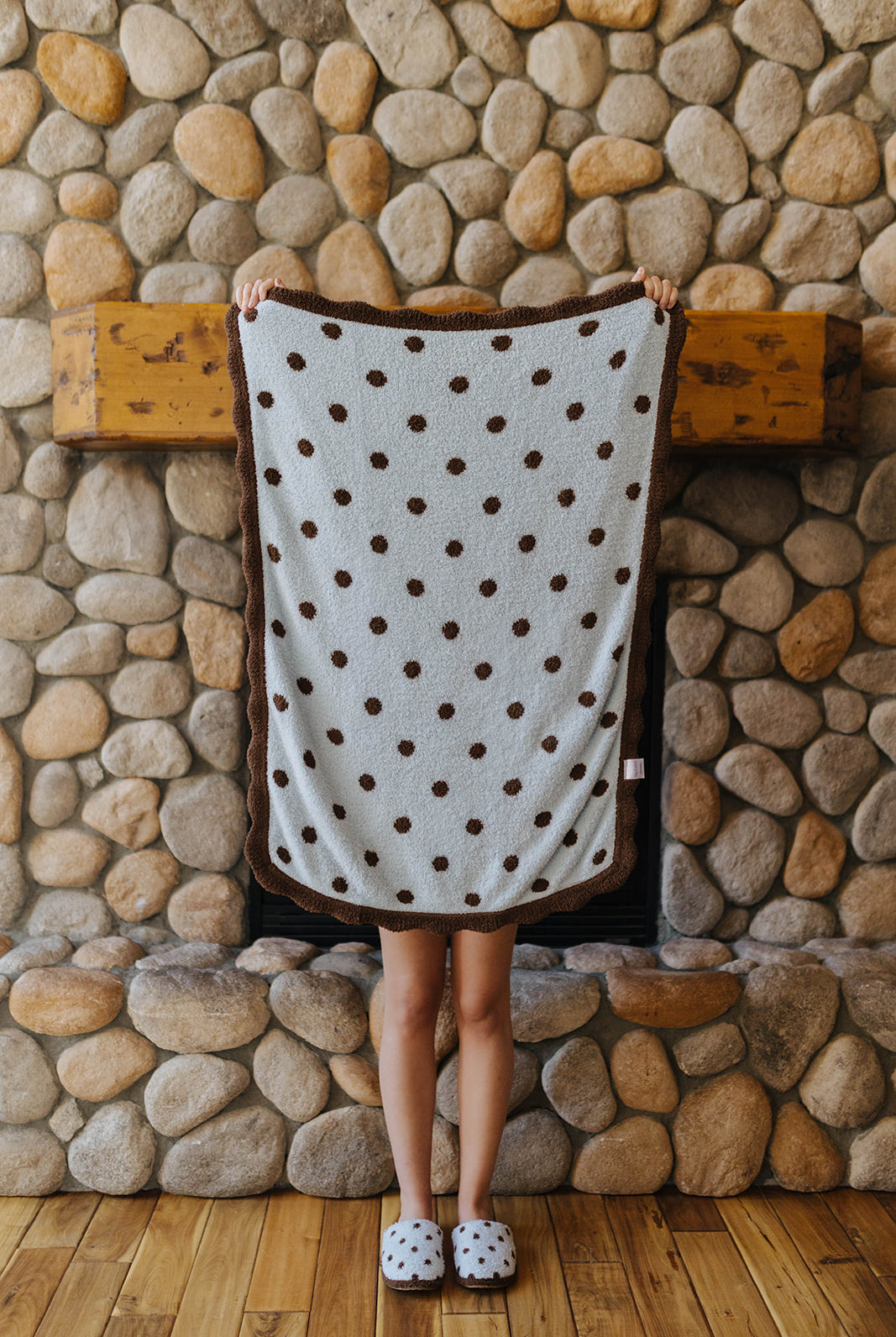 Light blue baby blanket with brown polka dots held open.