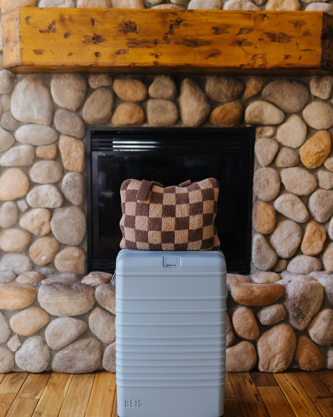 Brown check quillow folded on a suitcase.