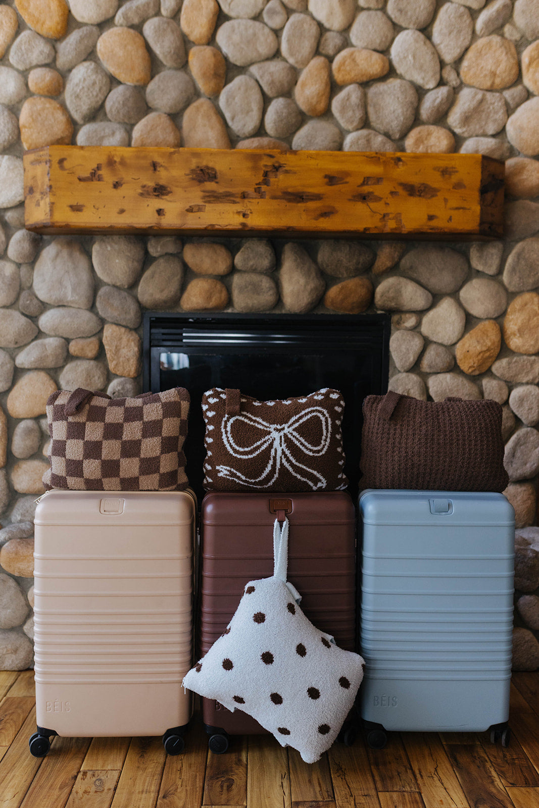 Check, bow, waffle, and polka dot quillows displayed with suitcases.