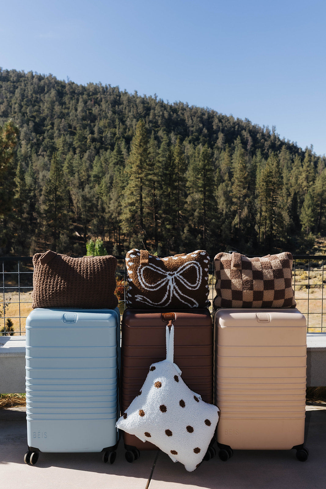 Four folded quillows displayed with suitcases outdoors.