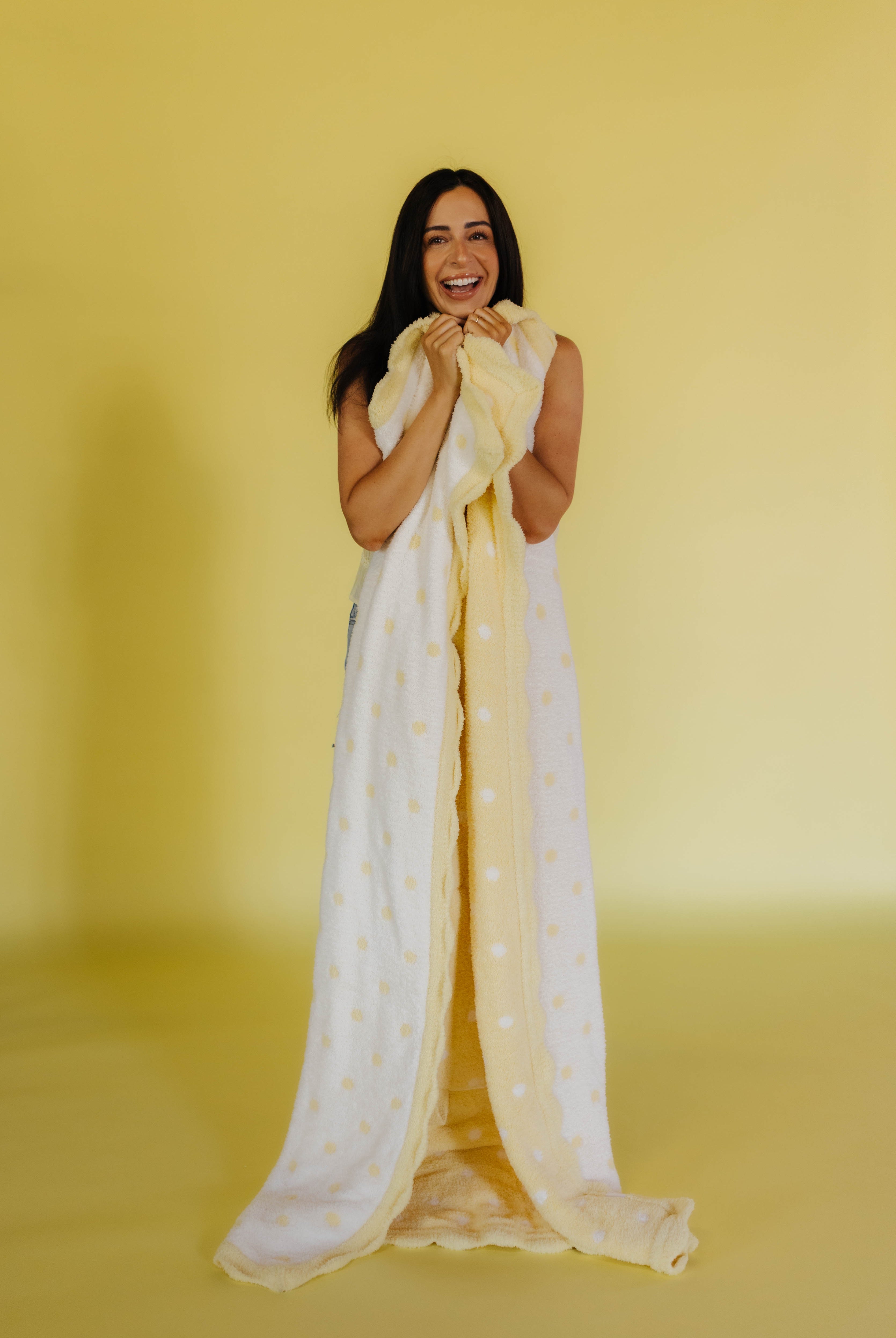 holding the white and yellow polka dot quillow