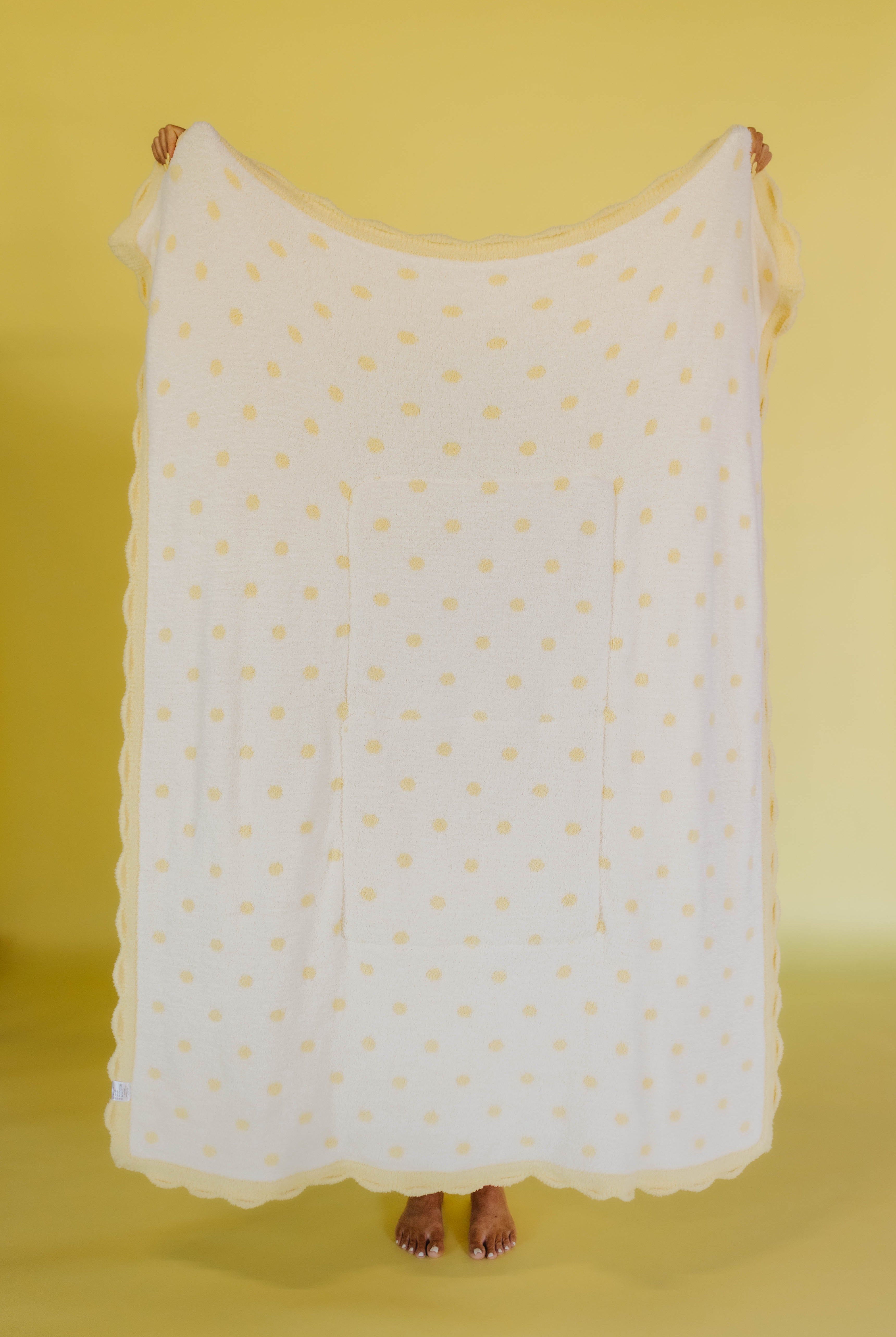 white side of yellow and white polka dot quillow