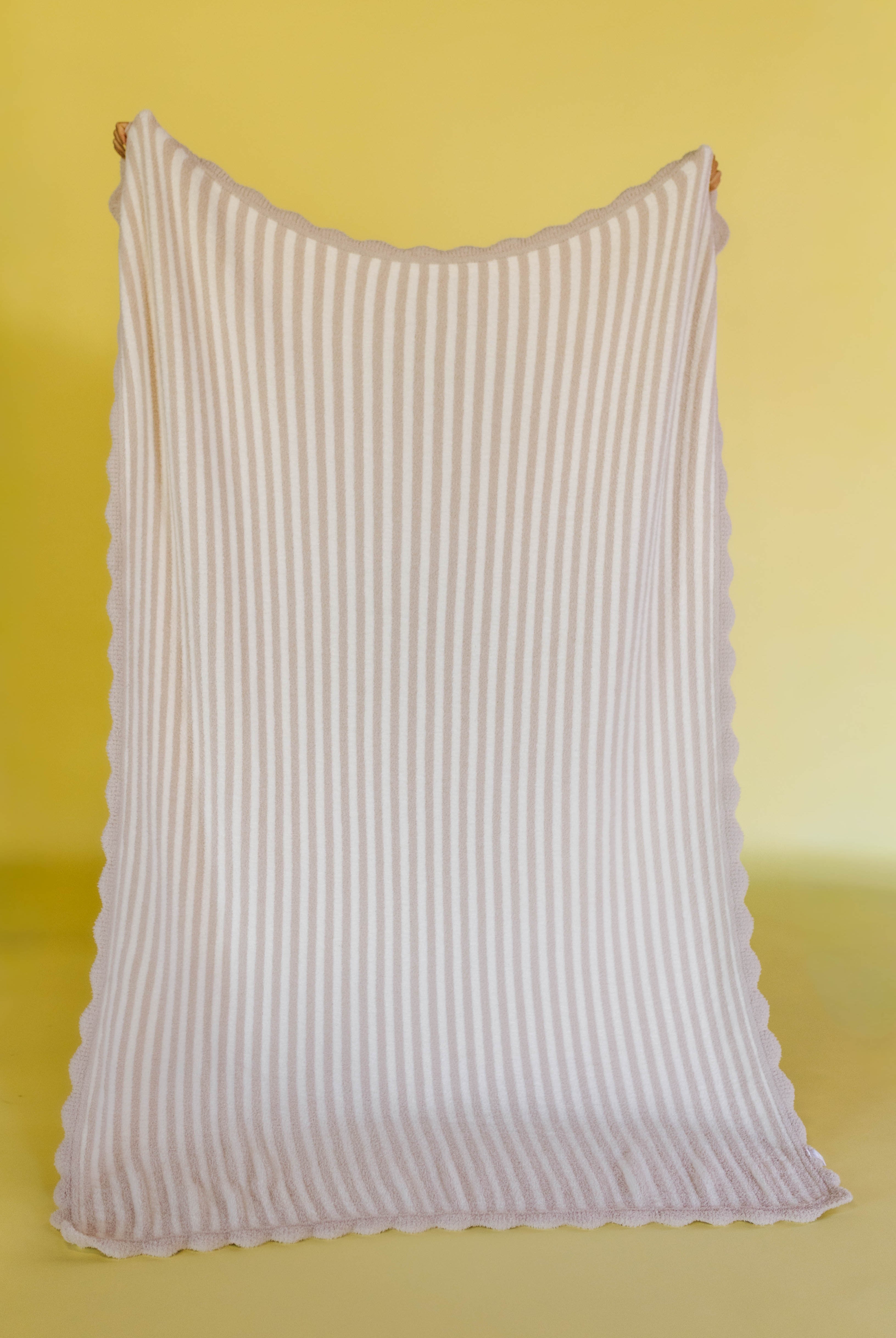 Pinstripe blanket with scallop detailing on a yellow background