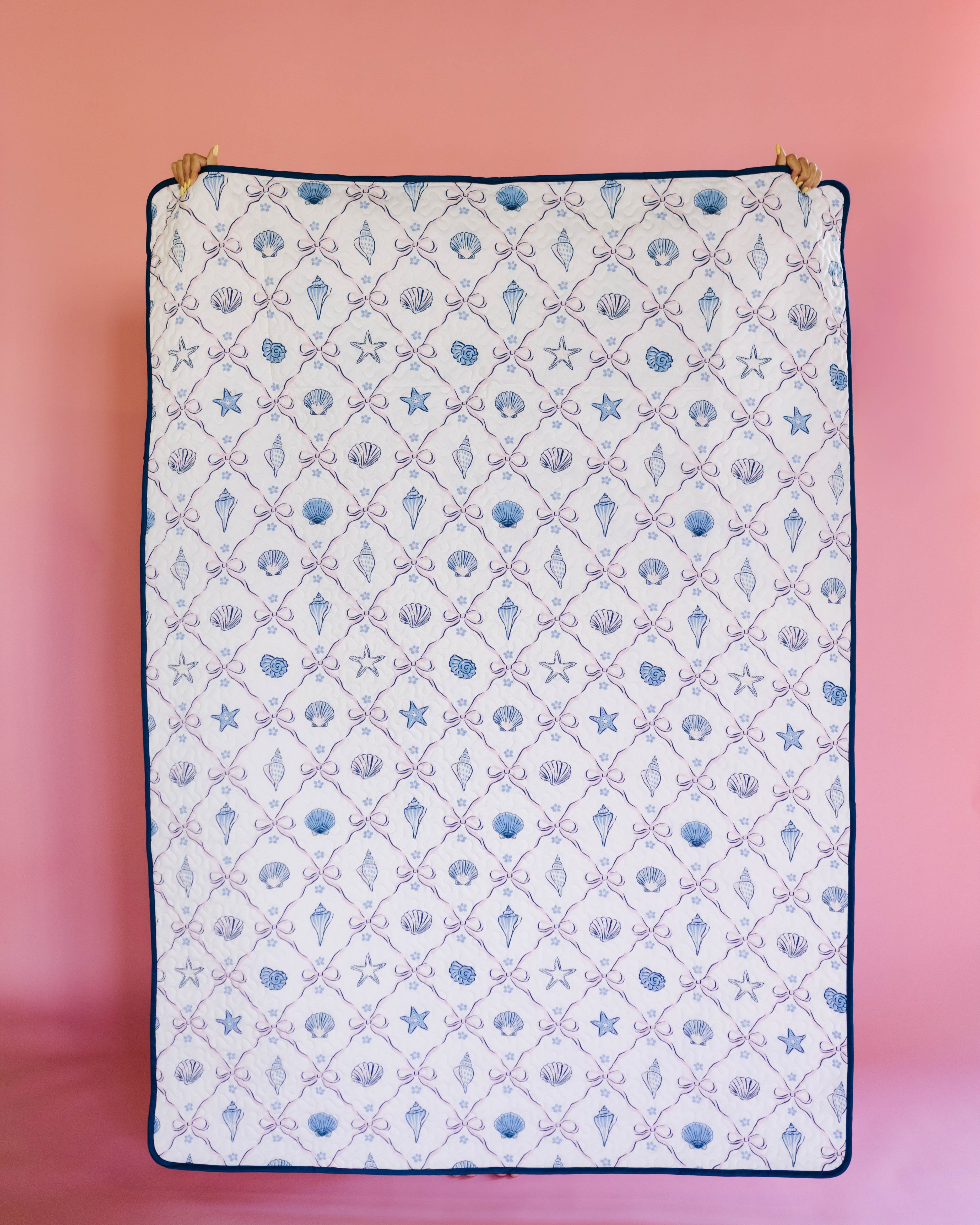 Patterned outdoor quillow/blanket with sea-themed design on a pink background