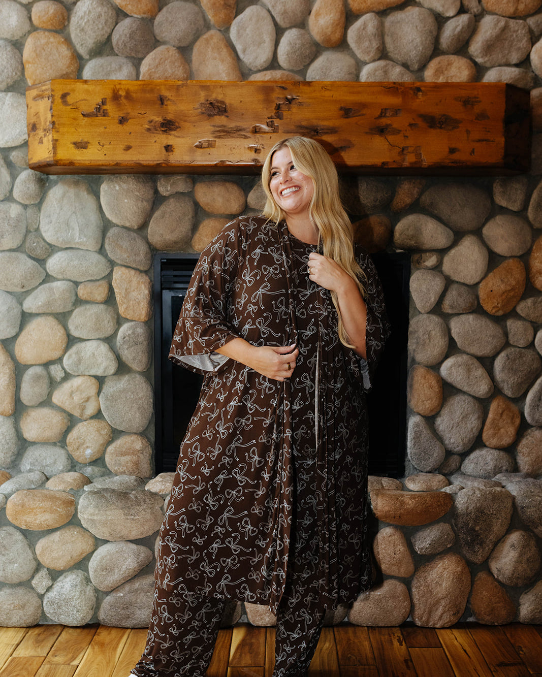 Full length front view of the brown bow print robe tied at the waist over matching pajamas.