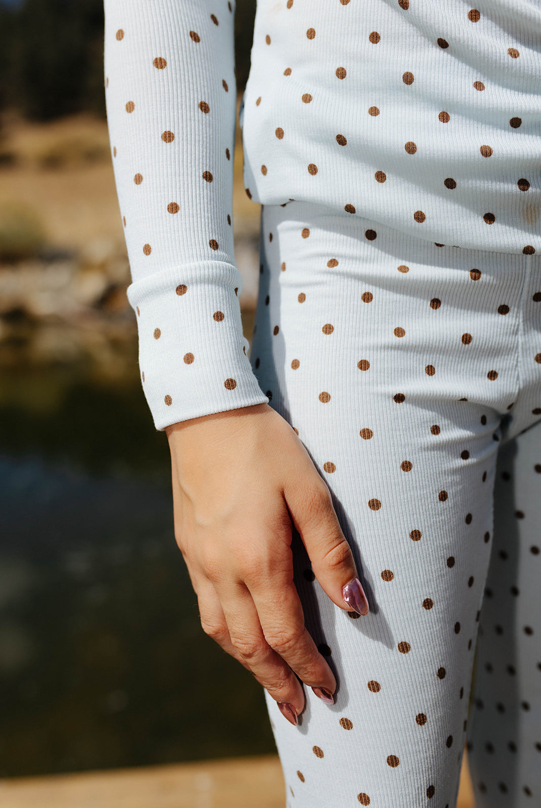 Close view of the kid blue and brown polka dot pajama waistband and sleeve.